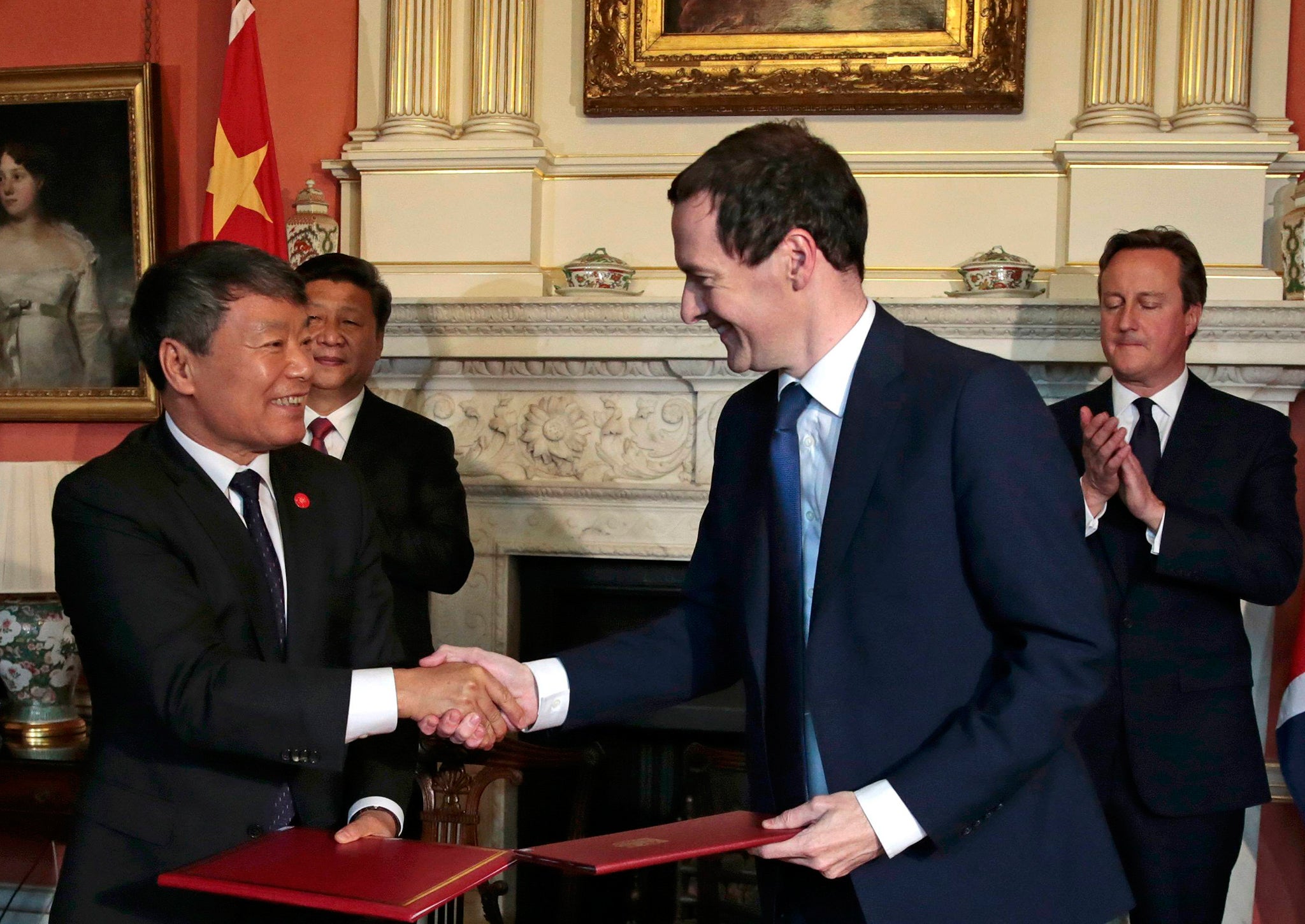 Geroge Osborne and China's Xu Shaoshi shake hands after signing an agreement