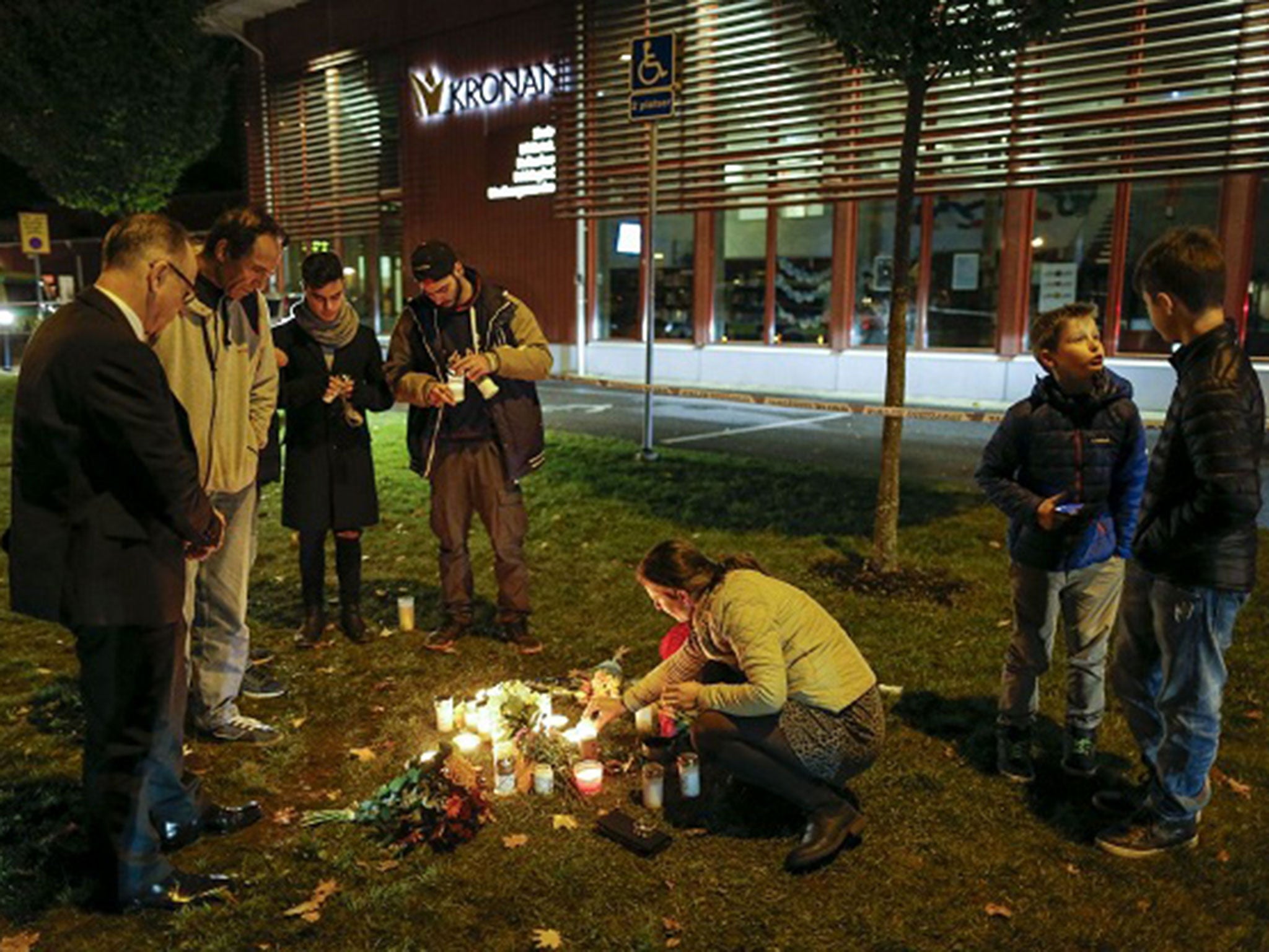 People light candles and lay flower tributes outside the Kronan school in Trollhattan