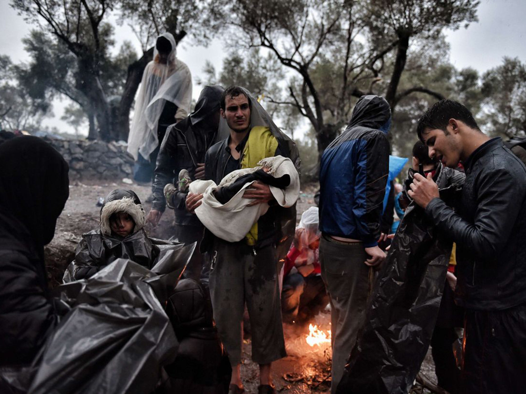 Migrants wait under outside the Moria registration camp on the Lesbos. Over 400,000 people have landed on Greek islands from neighbouring Turkey since the beginning of the year (AFP)