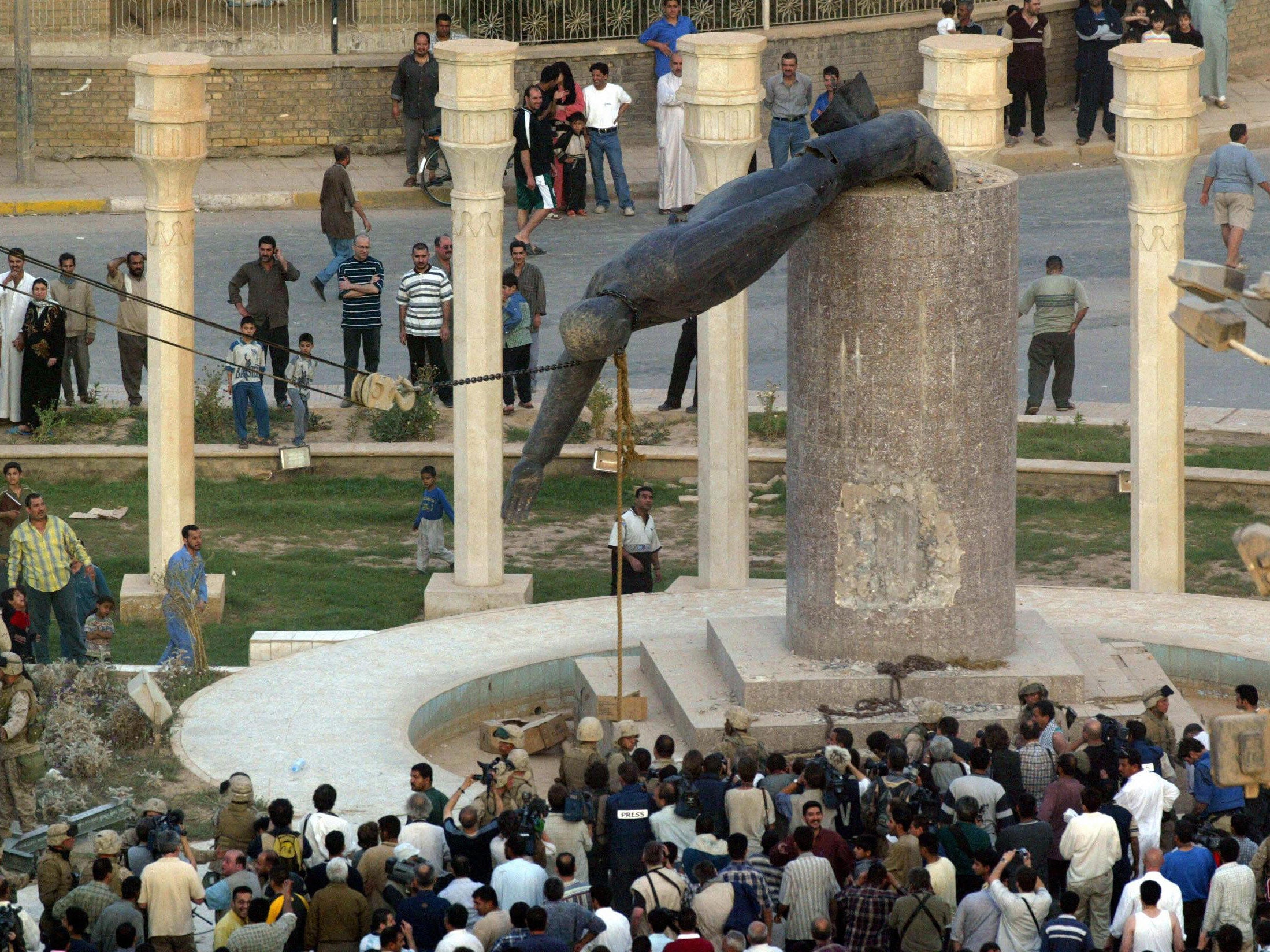 Iraqis watch a statue of ousted Iraqi President Saddam Hussein falling in Baghdad's al-Fardous square in 2003 Getty