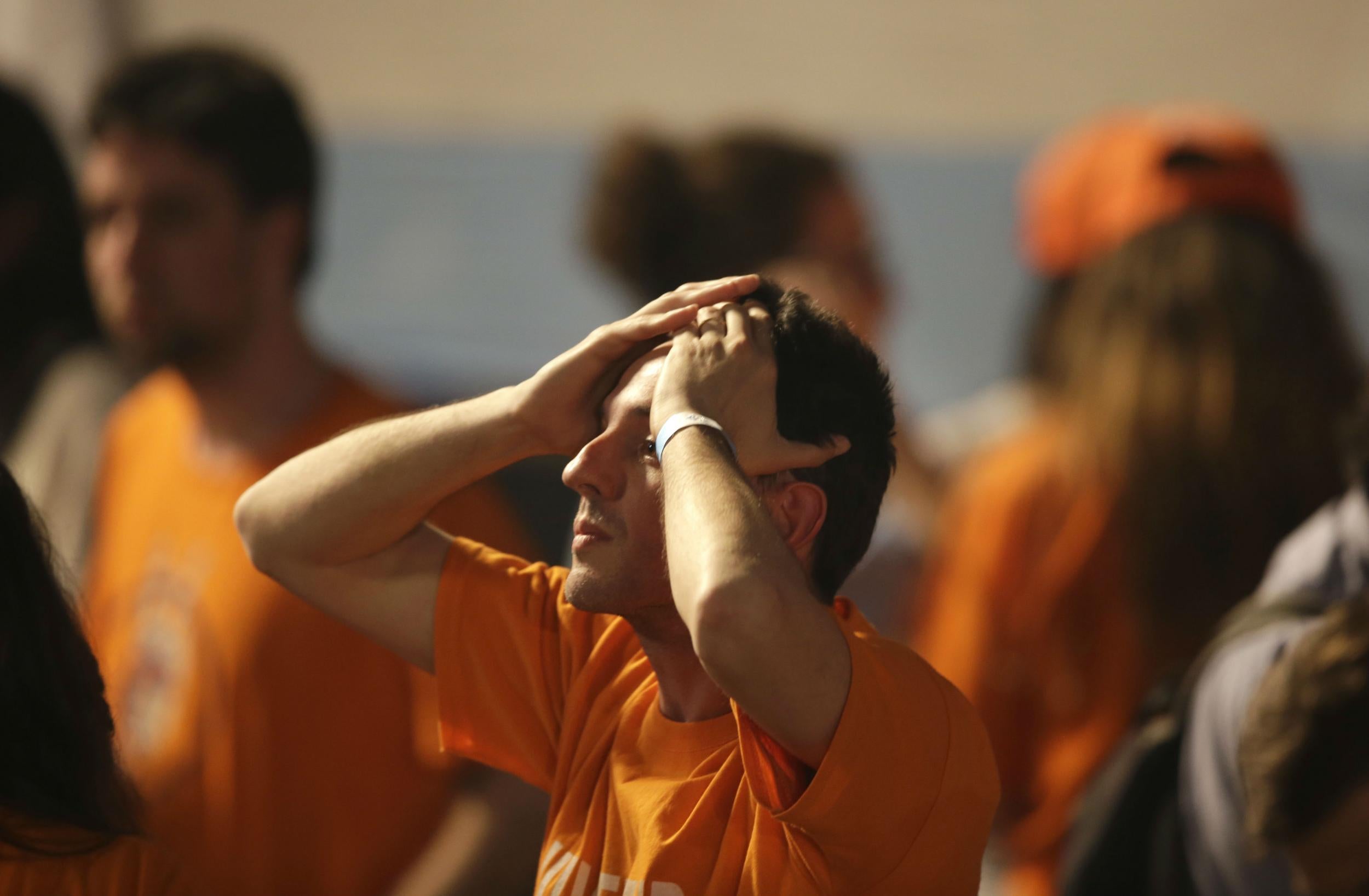 A supporter of ruling party presidential candidate, Buenos Aires' Gov. Daniel Scioli, reacts to hearing the first official results