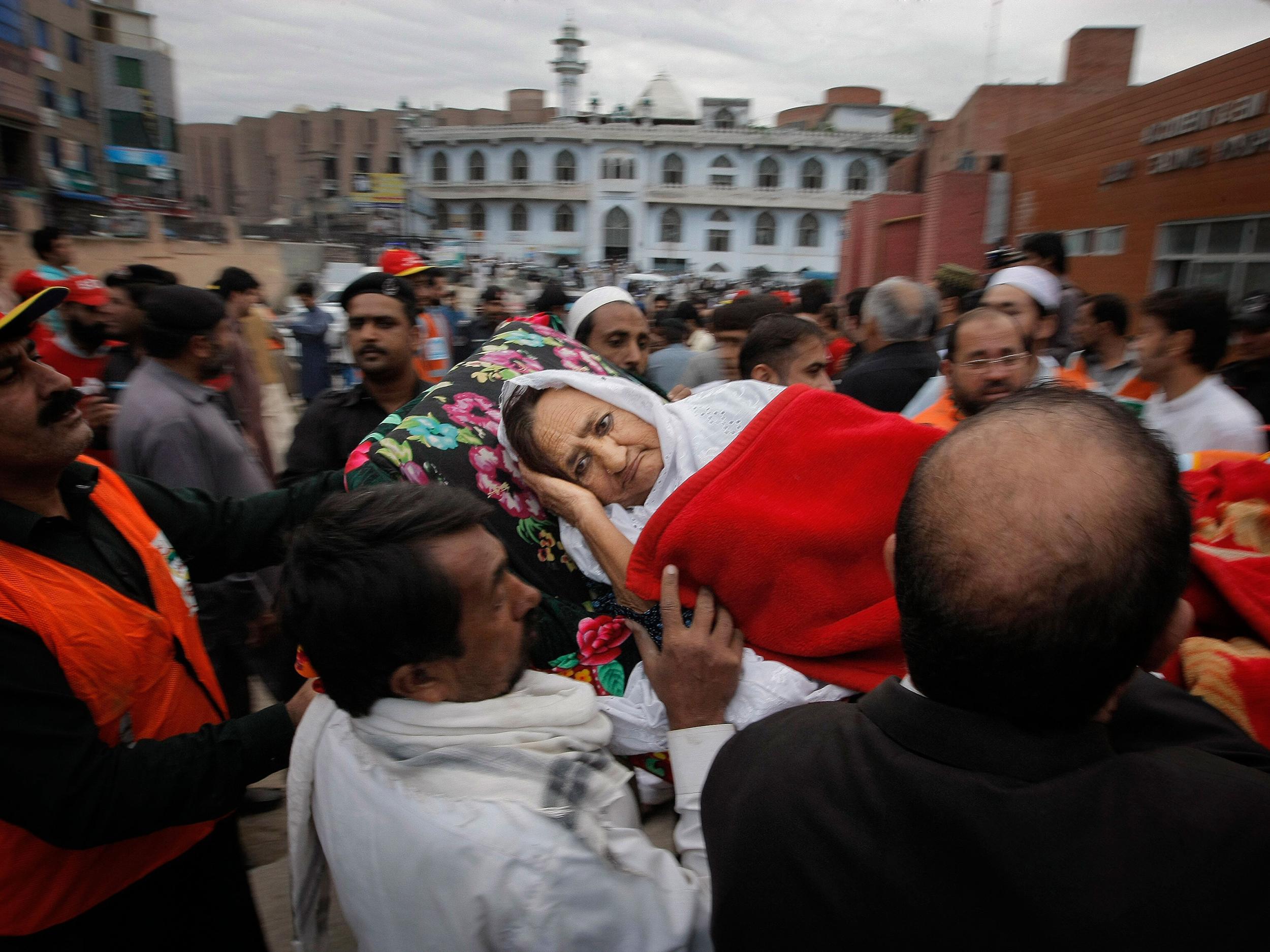 People rush an injured woman to a local hospital in Peshawar, Pakistan AP