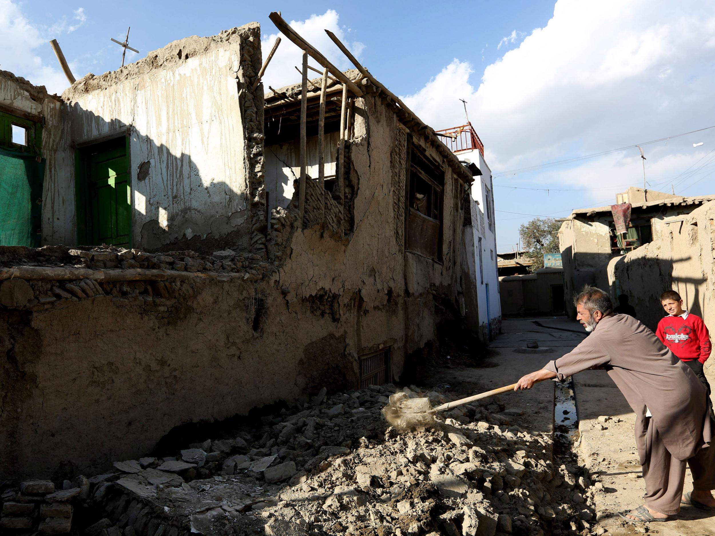 An Afghan man clears rubble from a damaged house in Kabul, Afghanistan AP