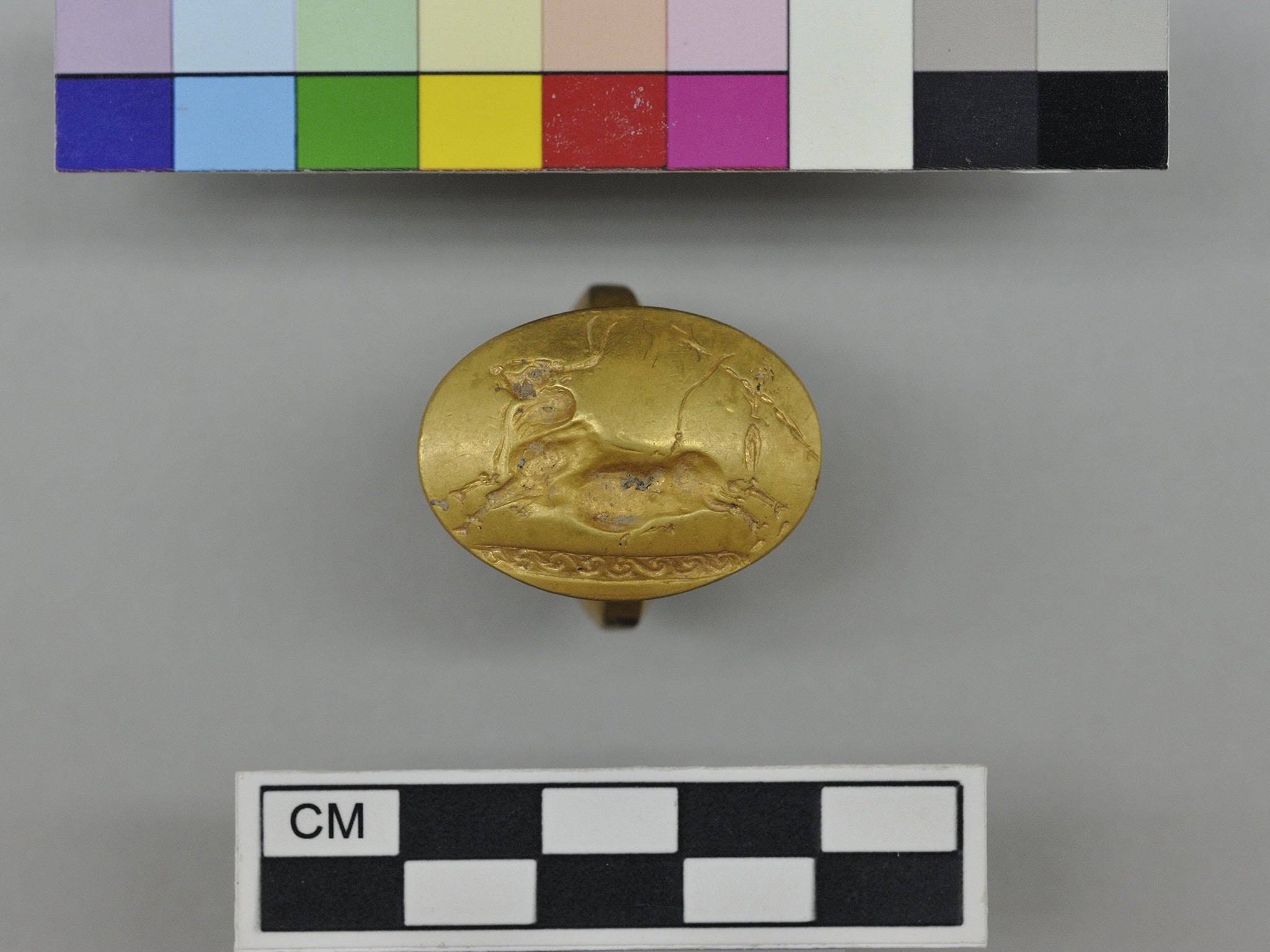 A gold signet ring decorated with two acrobats vaulting over a bull, found in a 3,500-year-old warrior’s tomb