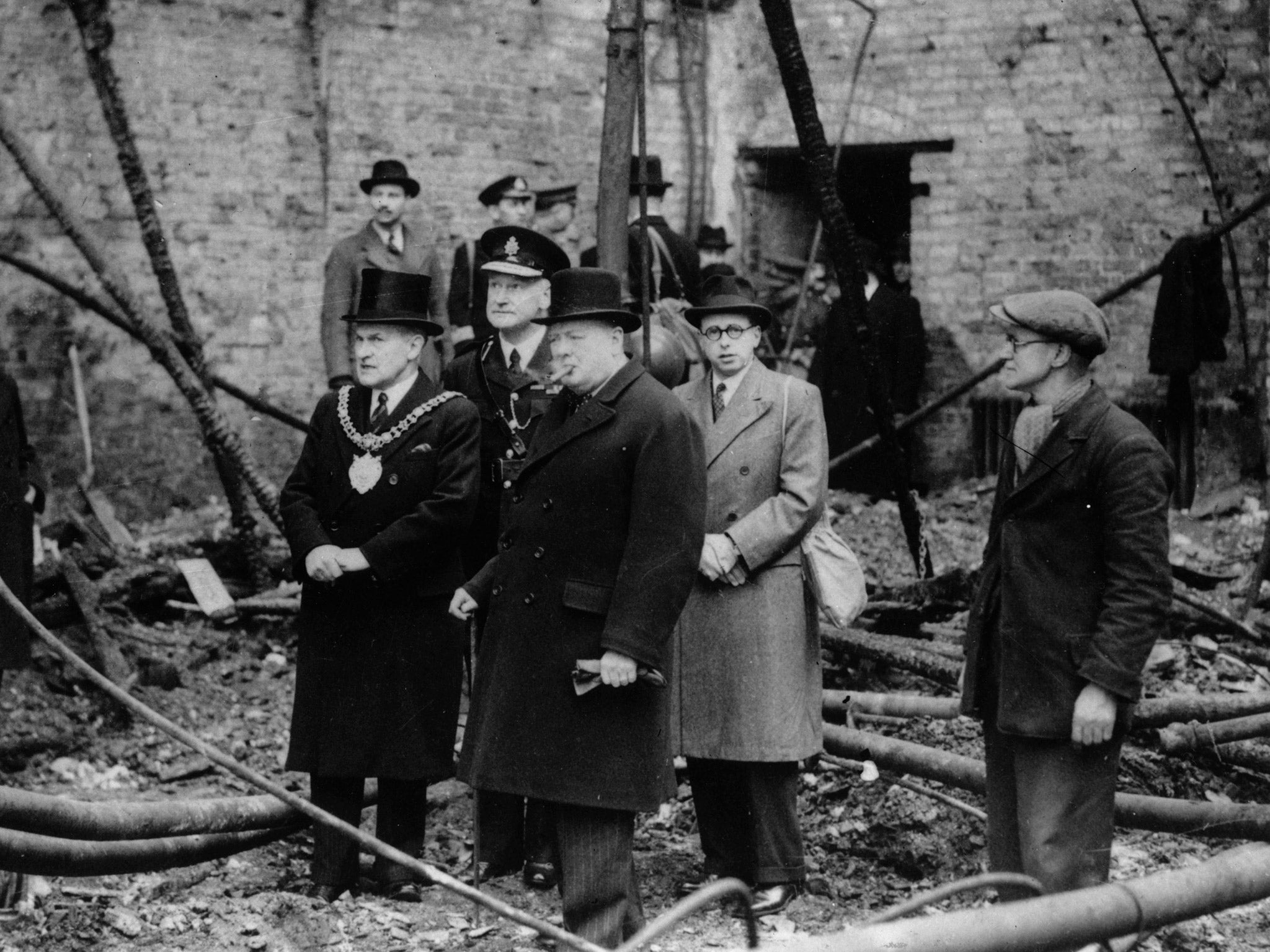 Prime Minister Winston Churchill inspecting the ruins of Manchester's Free Trade Hall after a bombing raid in WWII