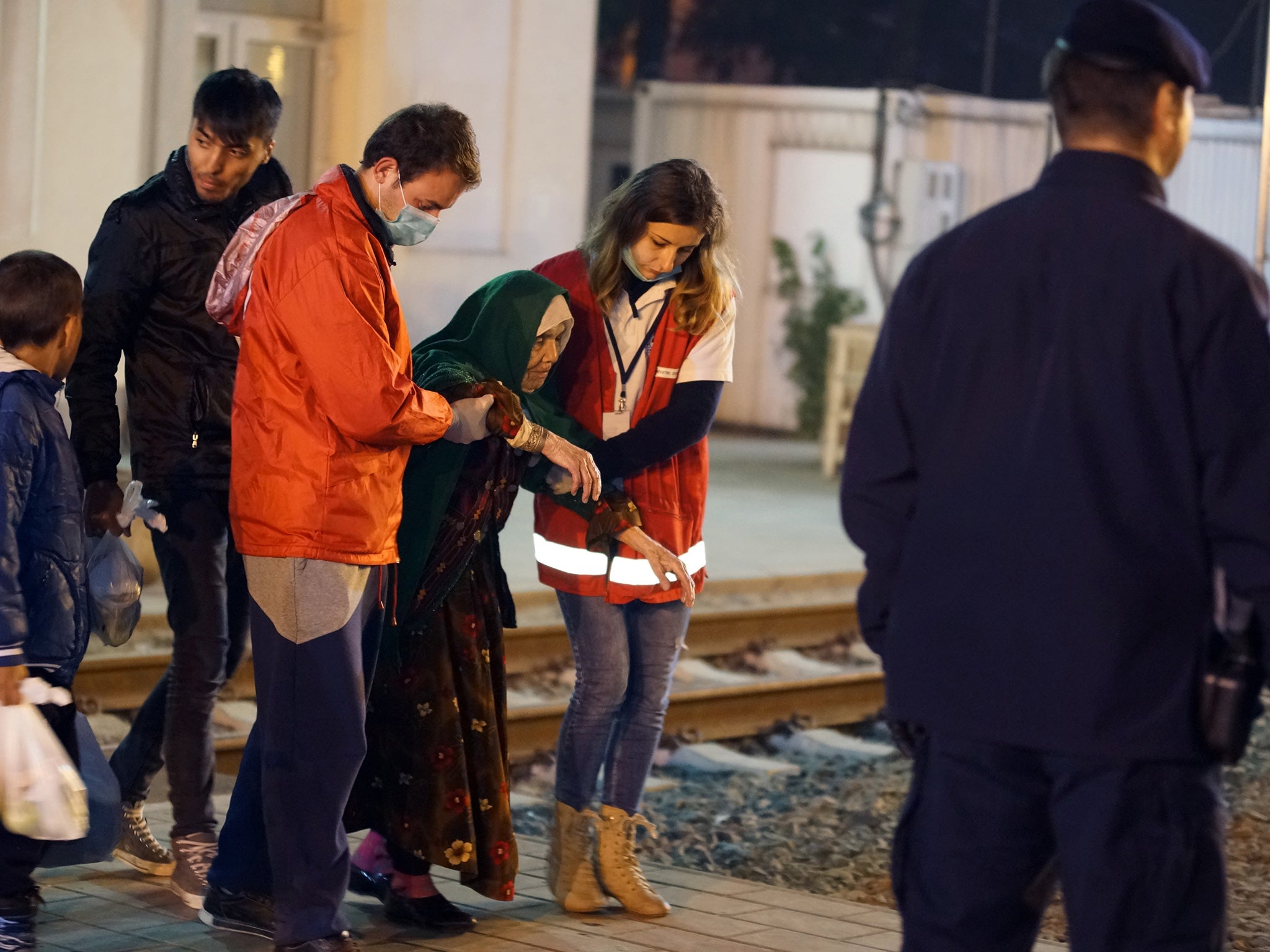 Volunteers help 105-year old Afghan refugee Bibihal Uzbeki from Kunduz, Afghanistan, in Croatia's main refugee camp at Opatovac