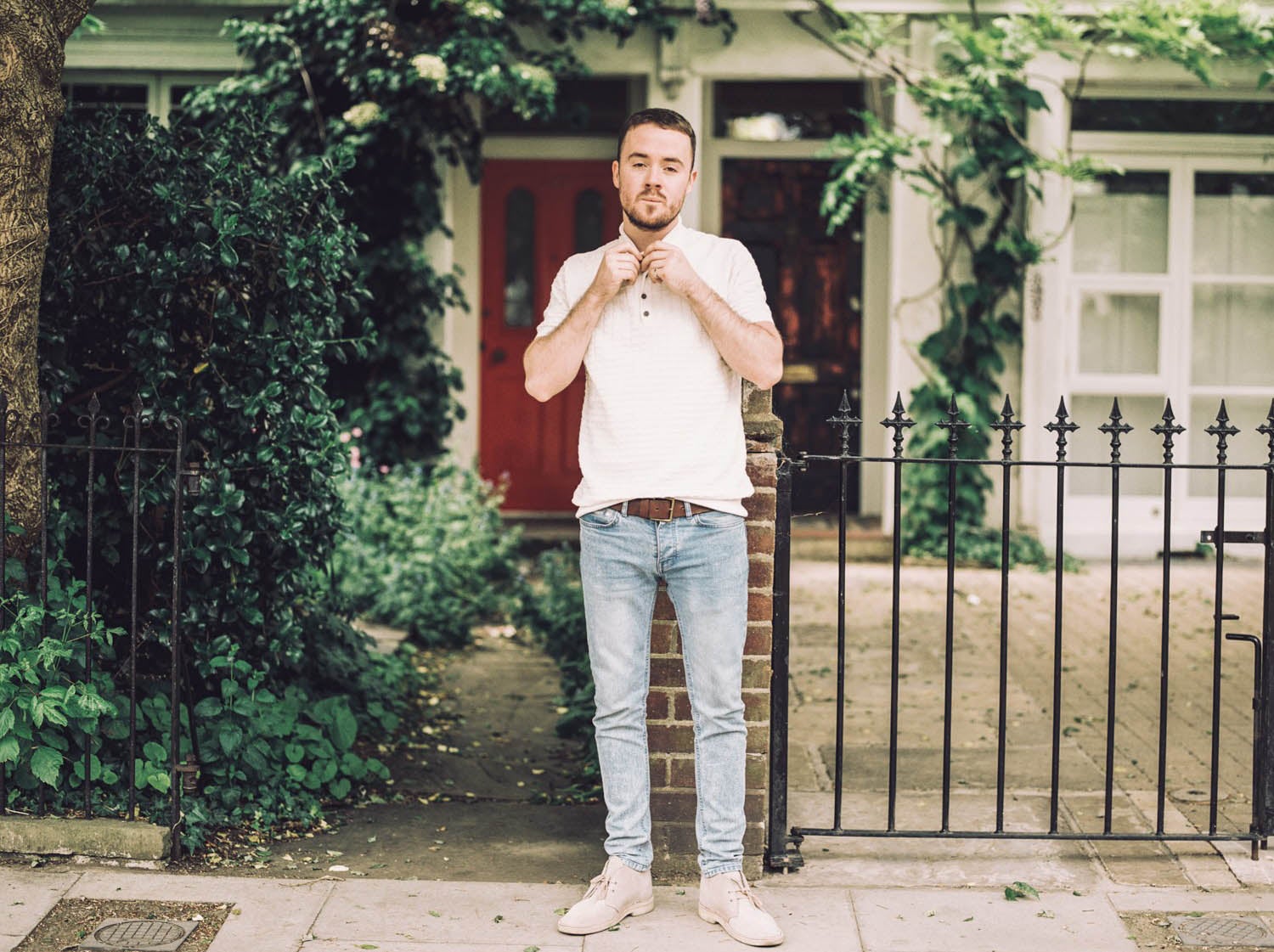 Maverick Sabre standing outside a ivy covered house