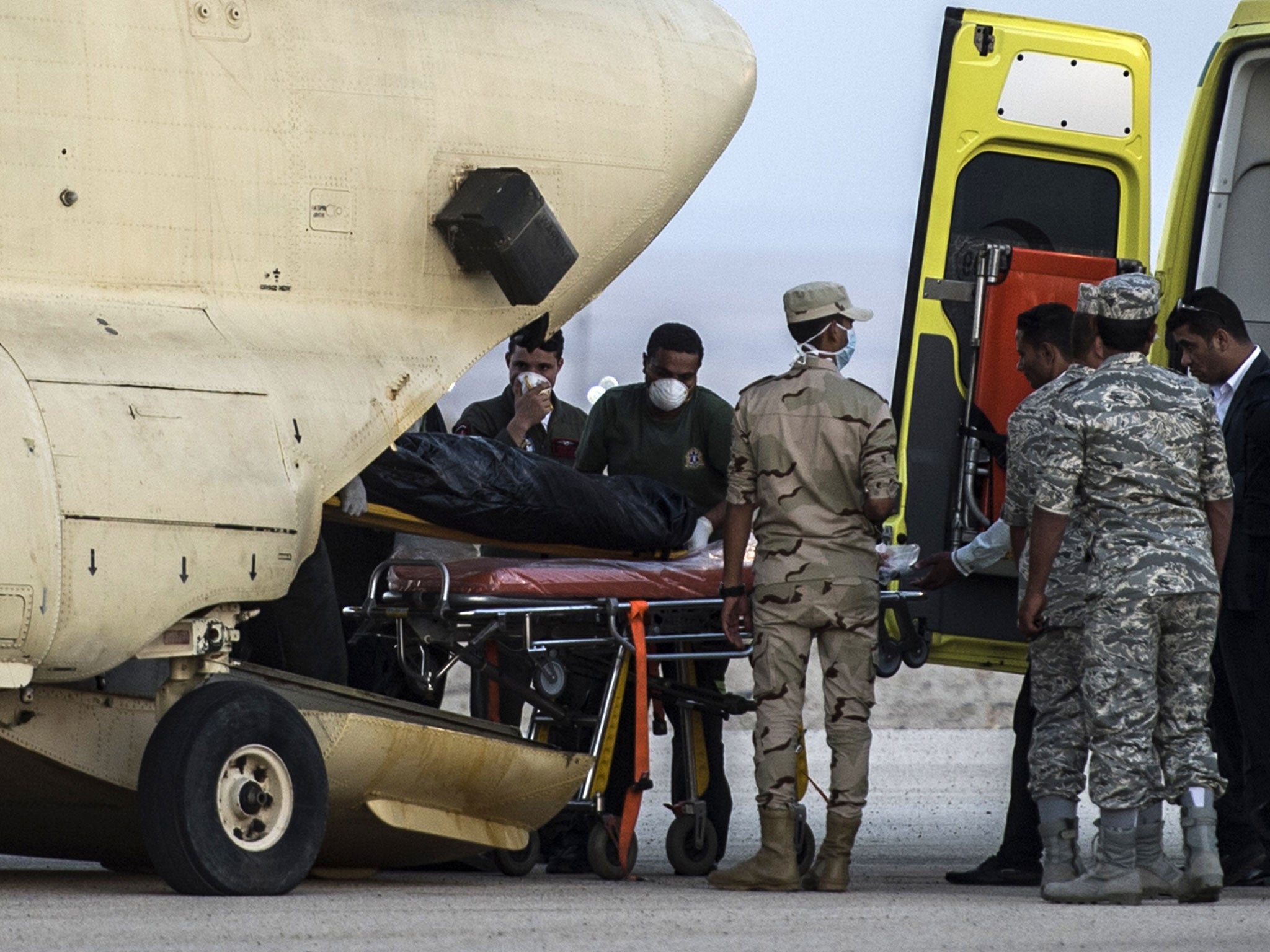 Egyptian paramedics load the corpses of victims into a military plane at Kabrit military air base by the Suez Canal on October 31, 2015