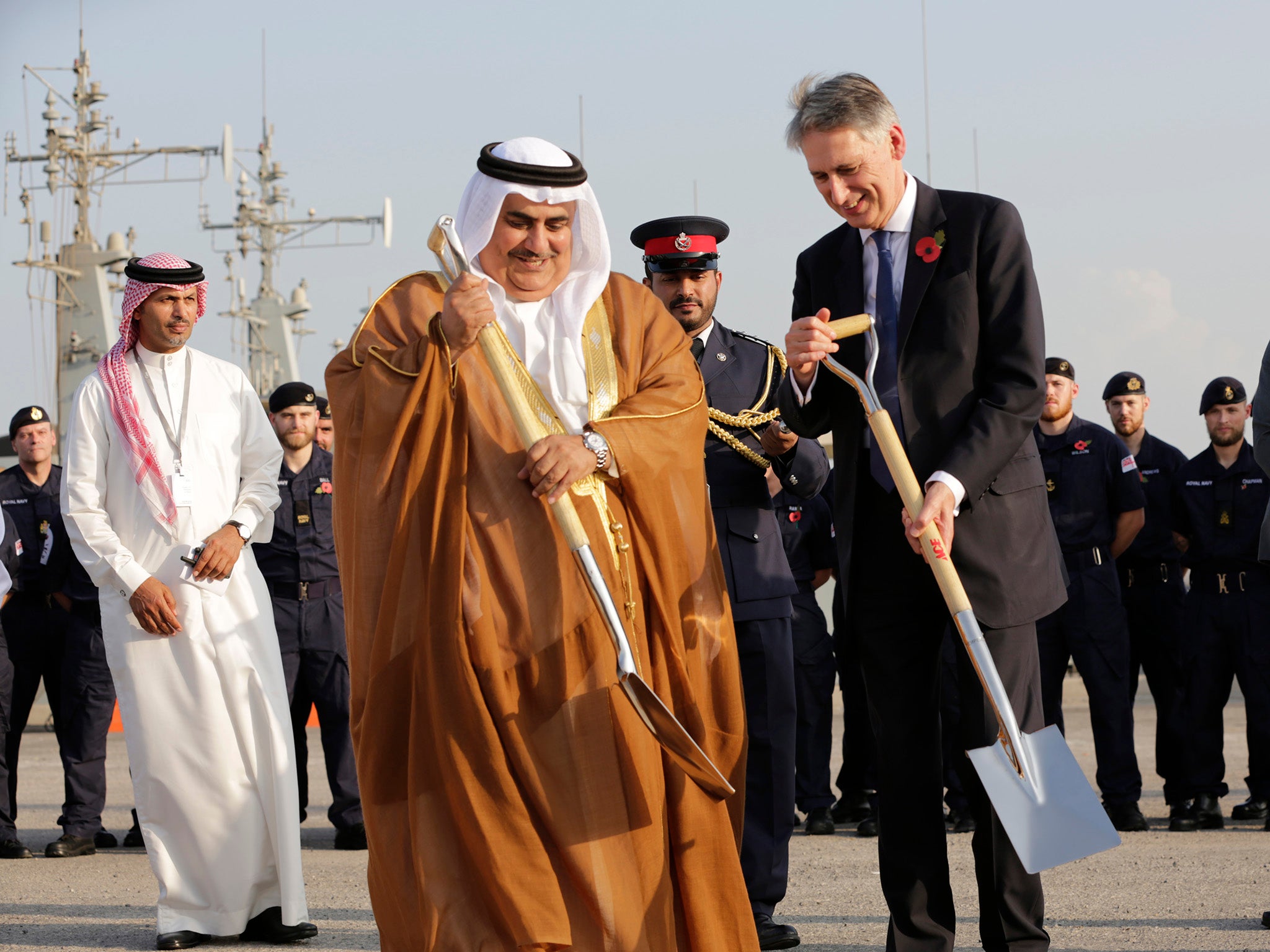 British Foreign Secretary Philip Hammond and Bahraini Foreign Minister Sheik Khalid bin Ahmed Al Khalifa, center help lay a cornerstone for a new British military base being built in Manama, Bahrain.