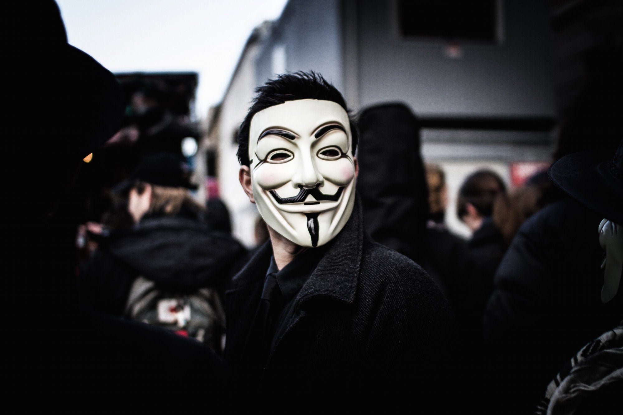 A guy rocks a Guye Fawkes mask.