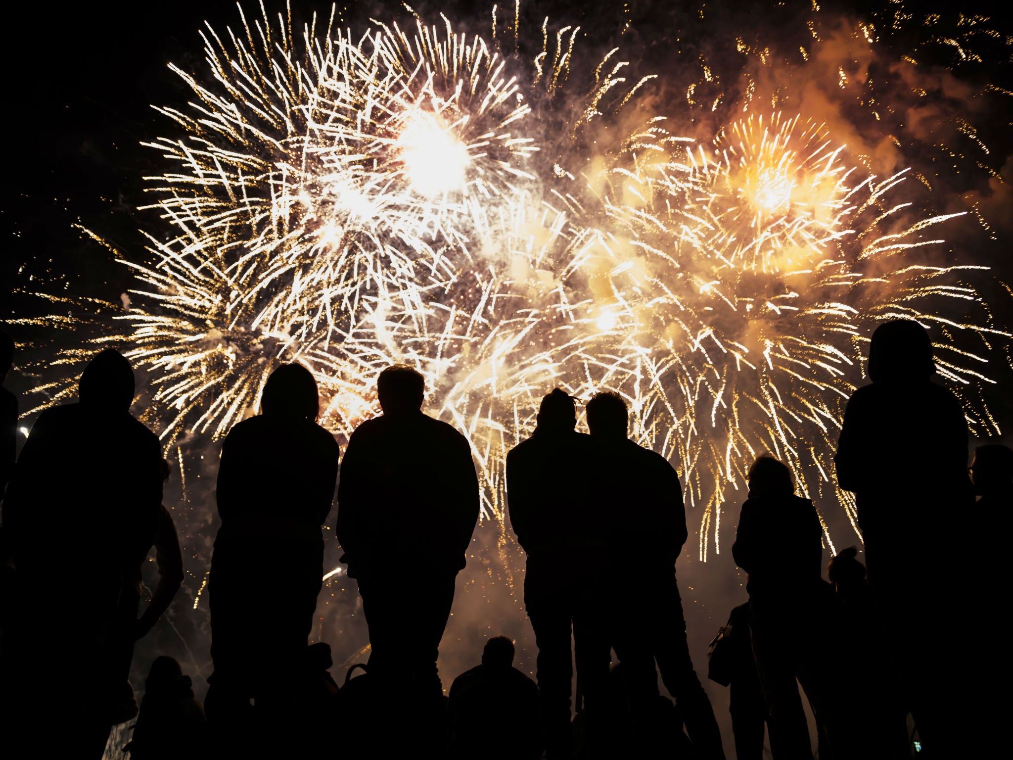 People watch a fireworks display, hopefully accompanied by music