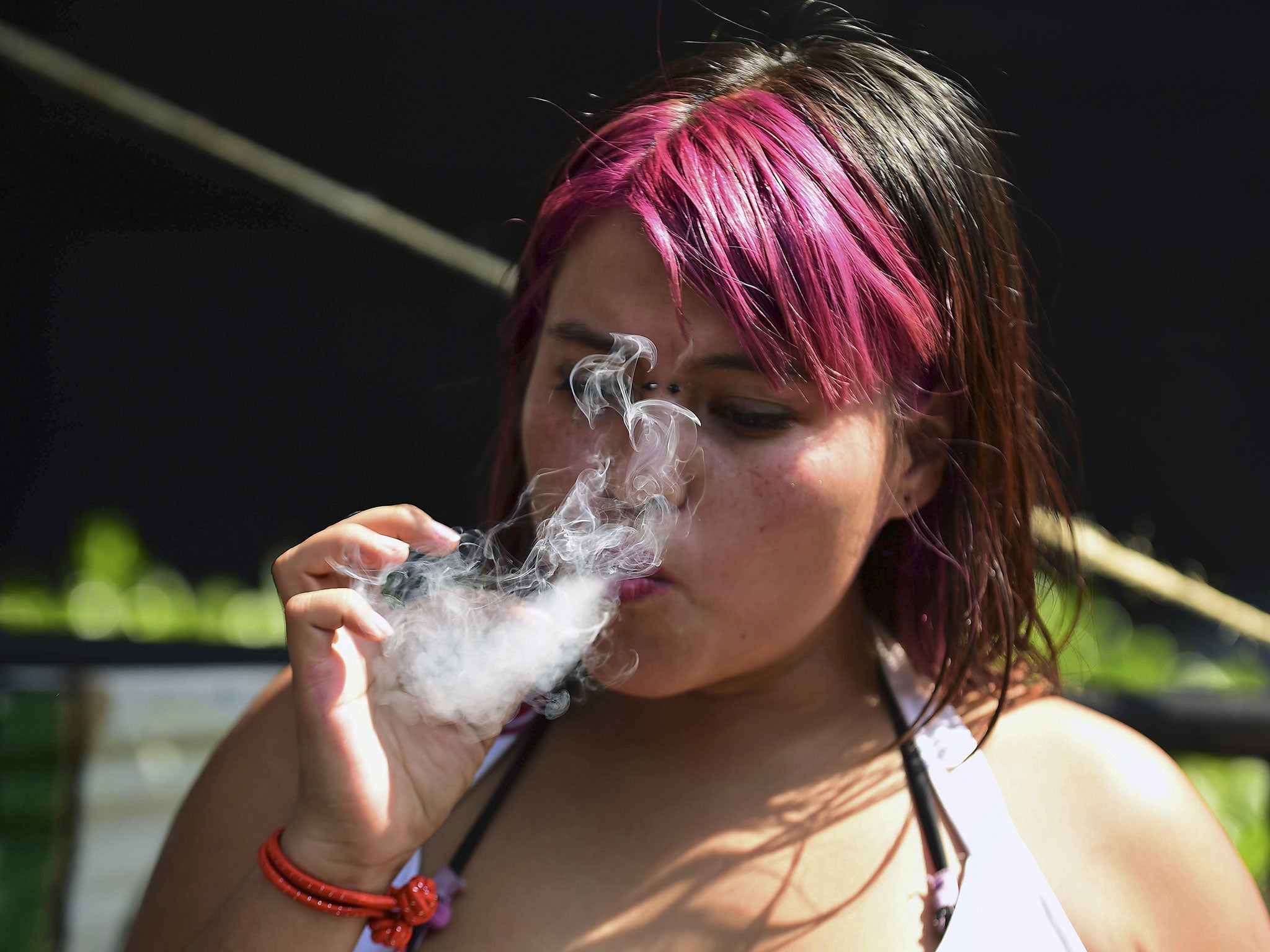 A woman smokes marijuana during a rally in front of the Supreme Court of Justice in Mexico City