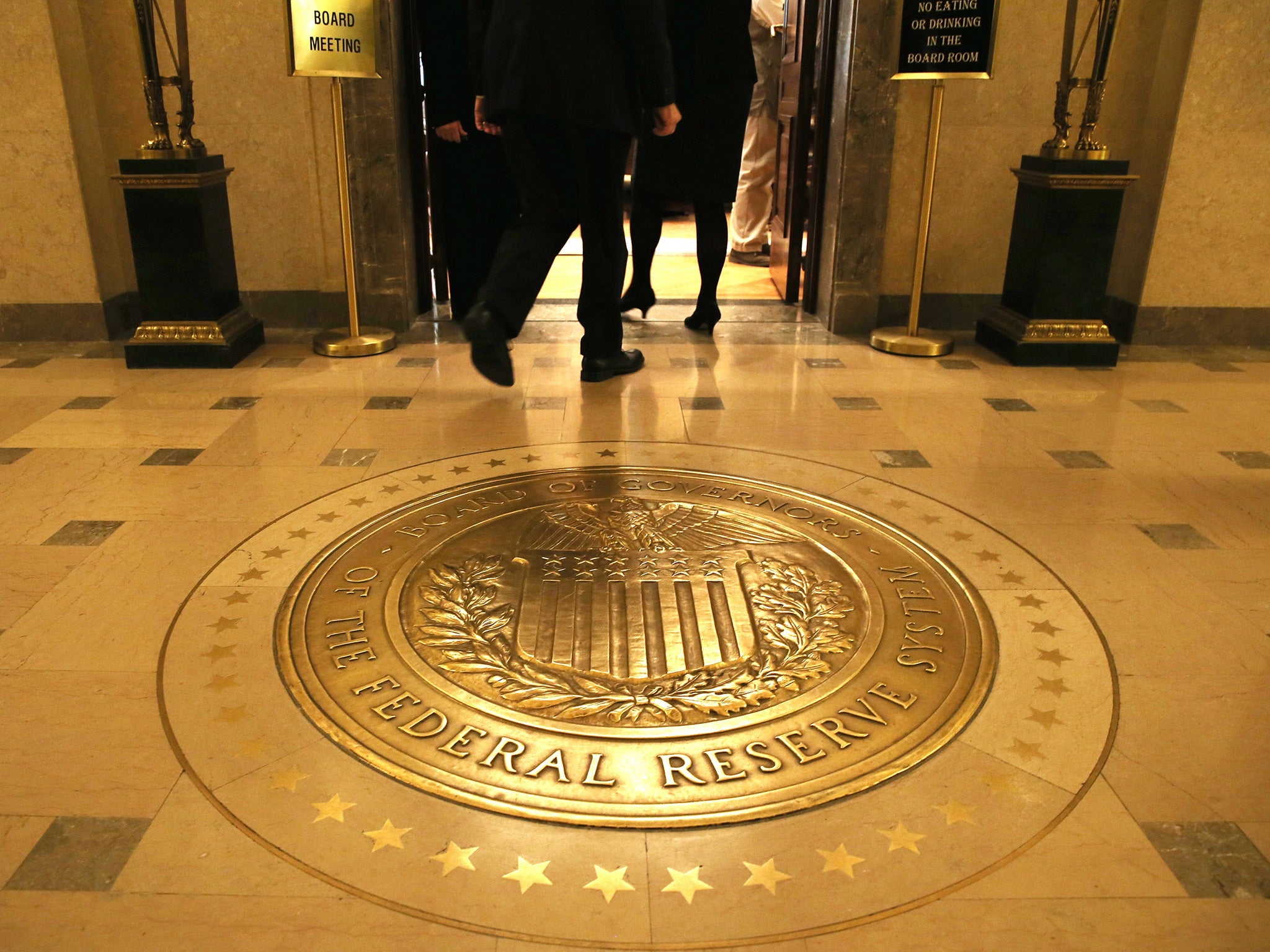 People walk into a meeting of the Board of Governors at the Federal Reserve