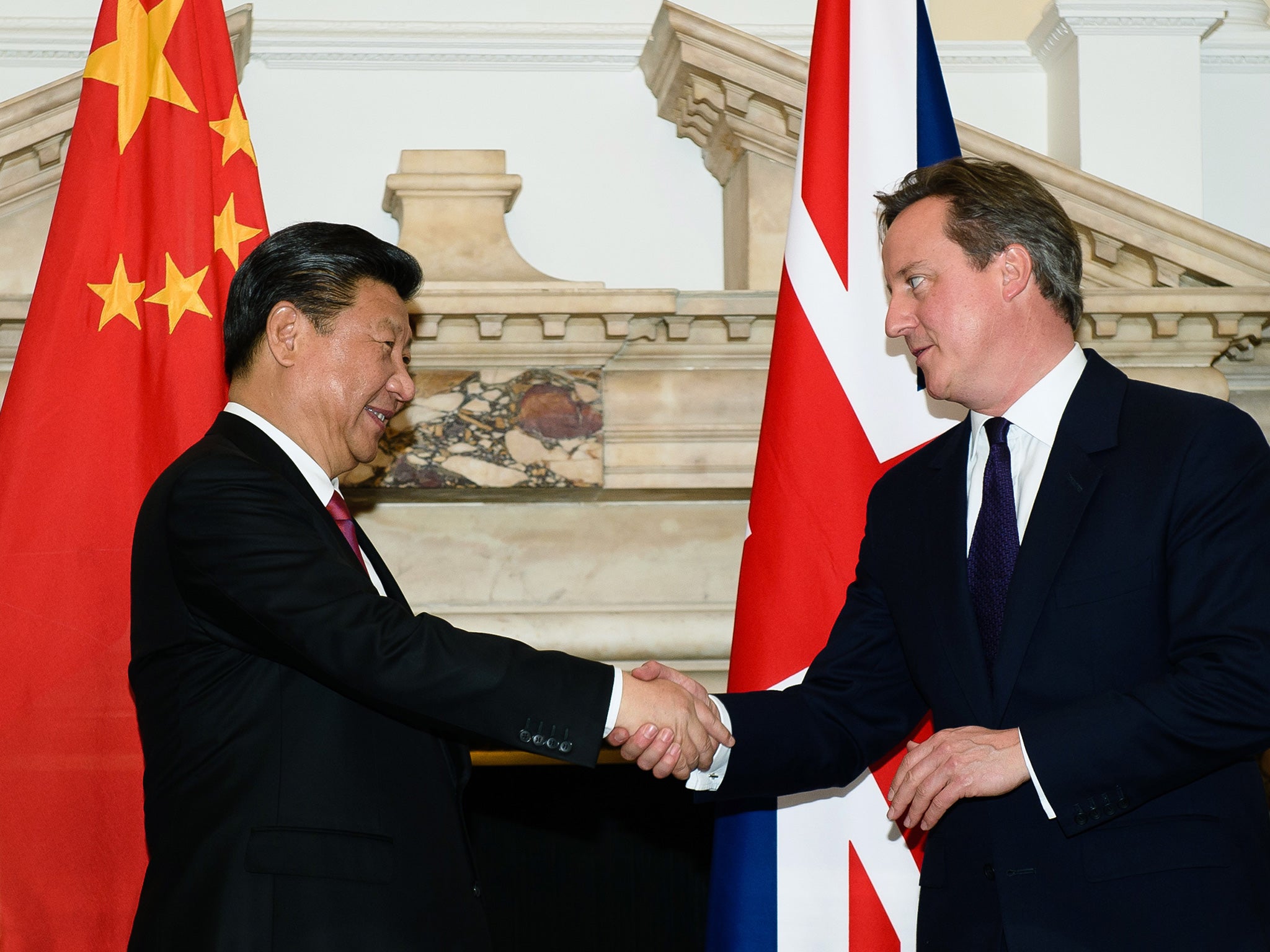 Chinese President Xi Jinping shakes the hand of David Cameron