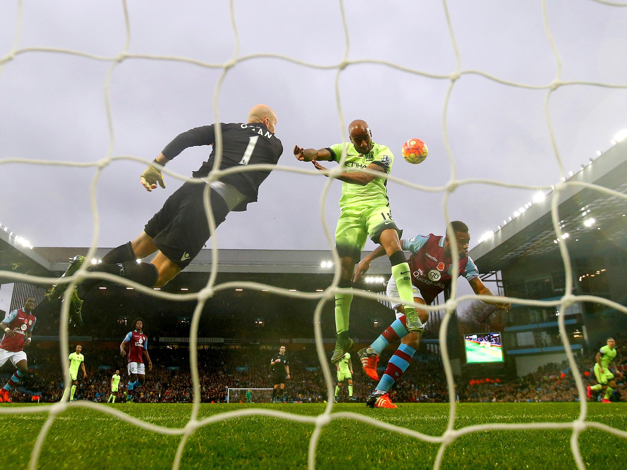 Vincent Kompany heads the ball onto the bar