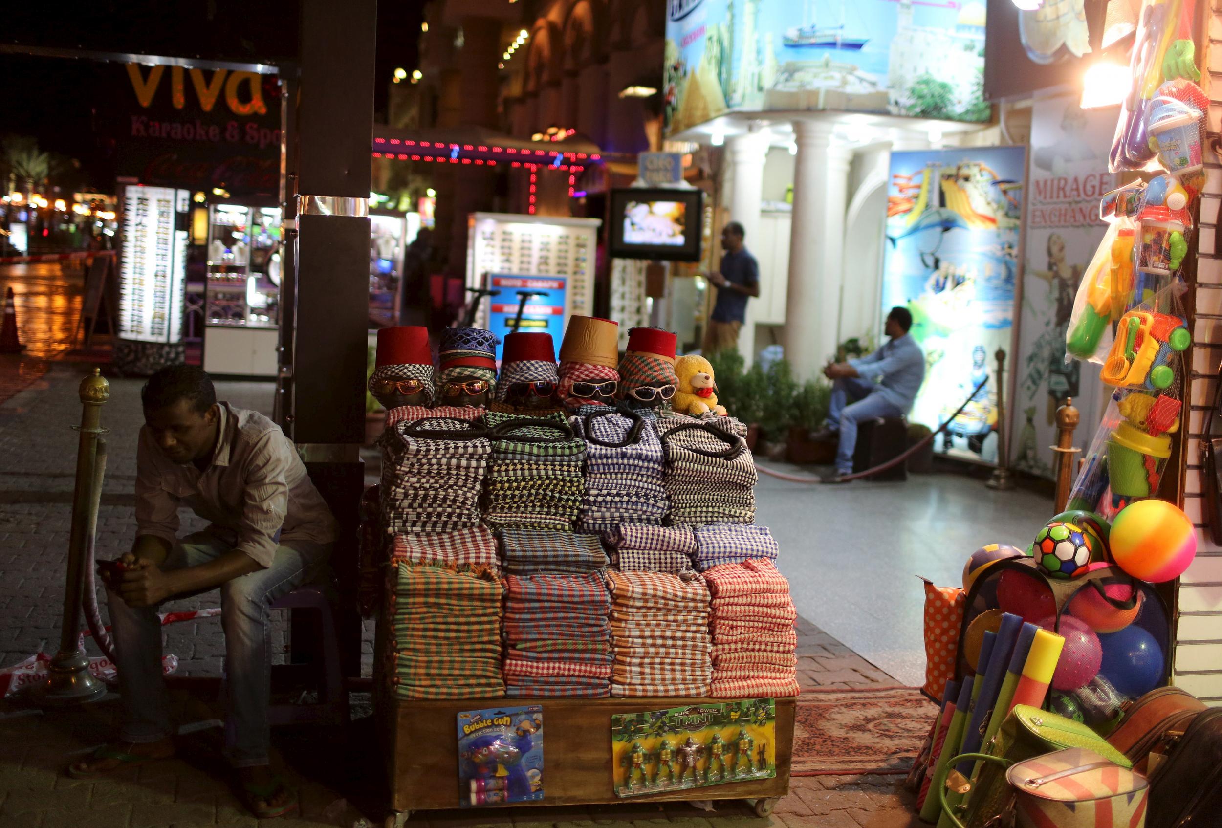 A vendor (front) and employees for excursion trips wait for customers in Naama bay area at the Red Sea resort of Sharm el-Sheikh, November 8, 2015.