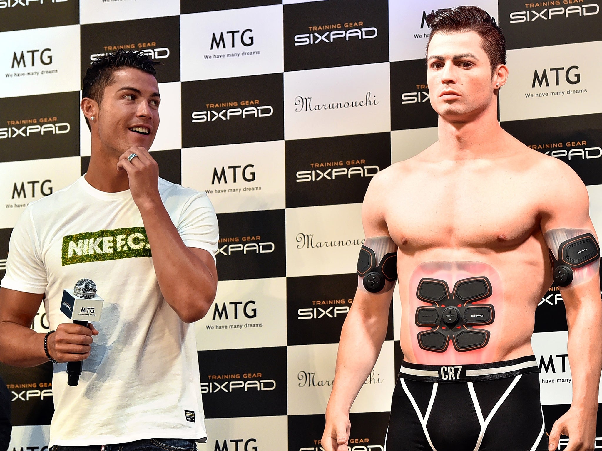 Cristiano Ronaldo casts an eye over his lookalike figure made by a 3D printer during a promotional event in Tokyo in July