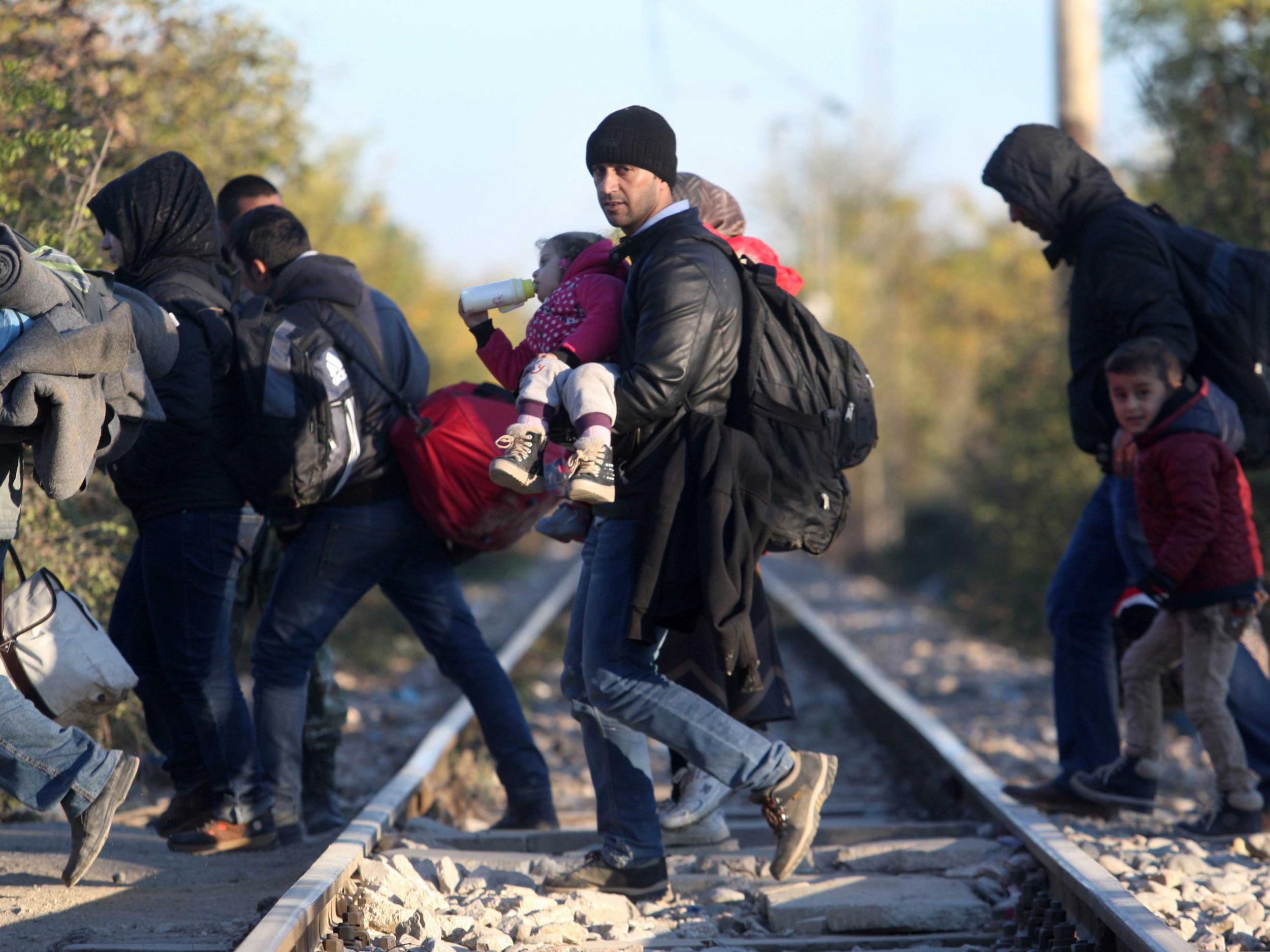 Refugees cross the border from Greece to Macedonia near the village of Idomeni