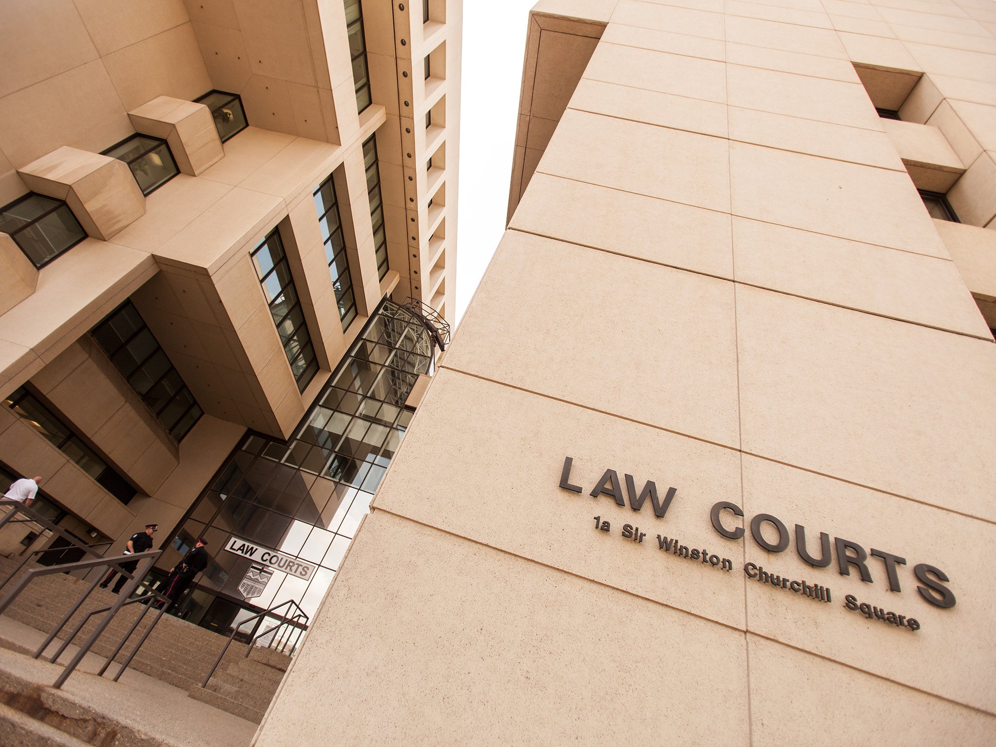 Police stand on the steps of the Law Courts in downtown Edmonton, Alberta