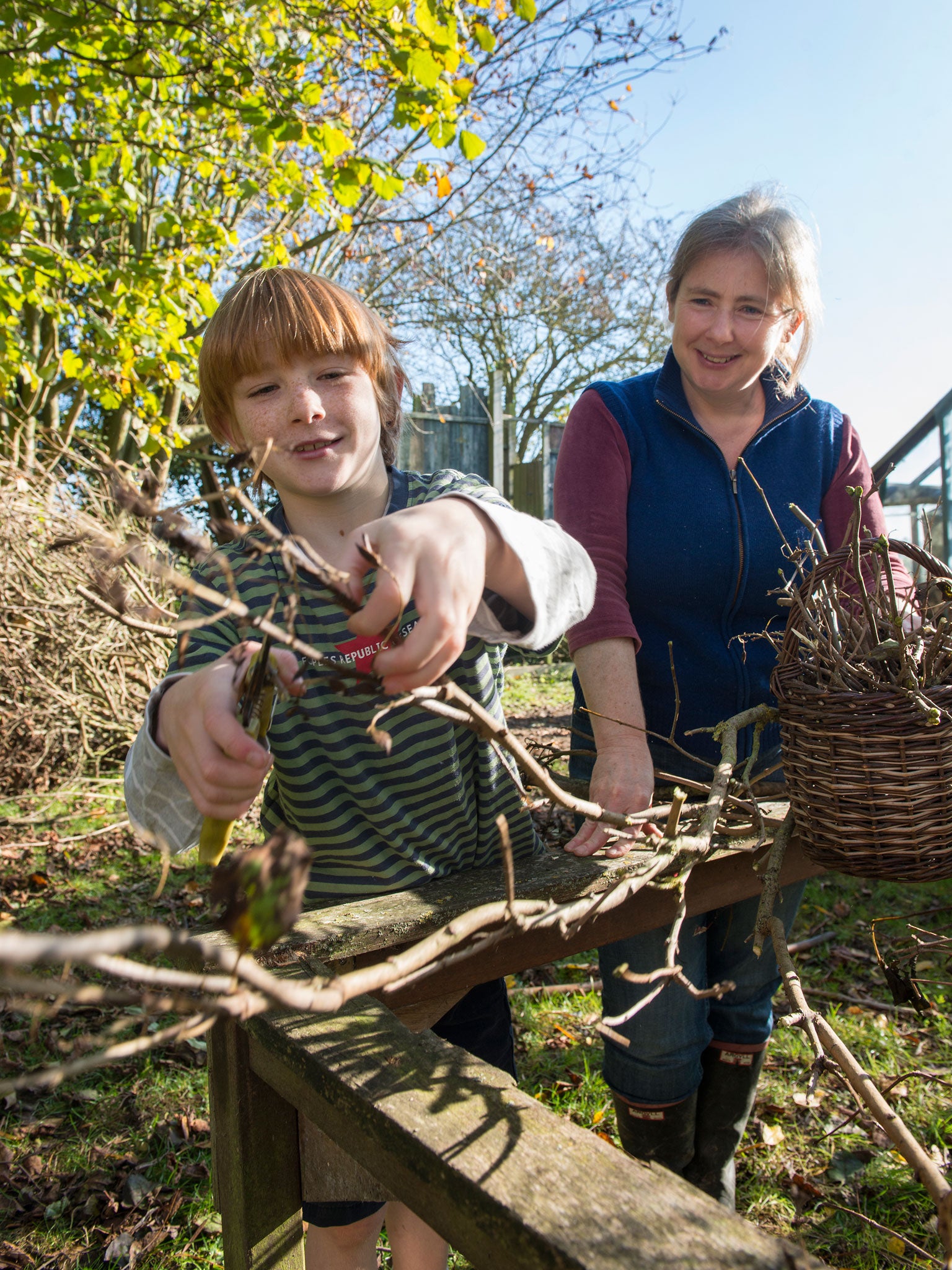 Rebecca Mitchell supervises her son Jamie as he cuts some branches with secateurs