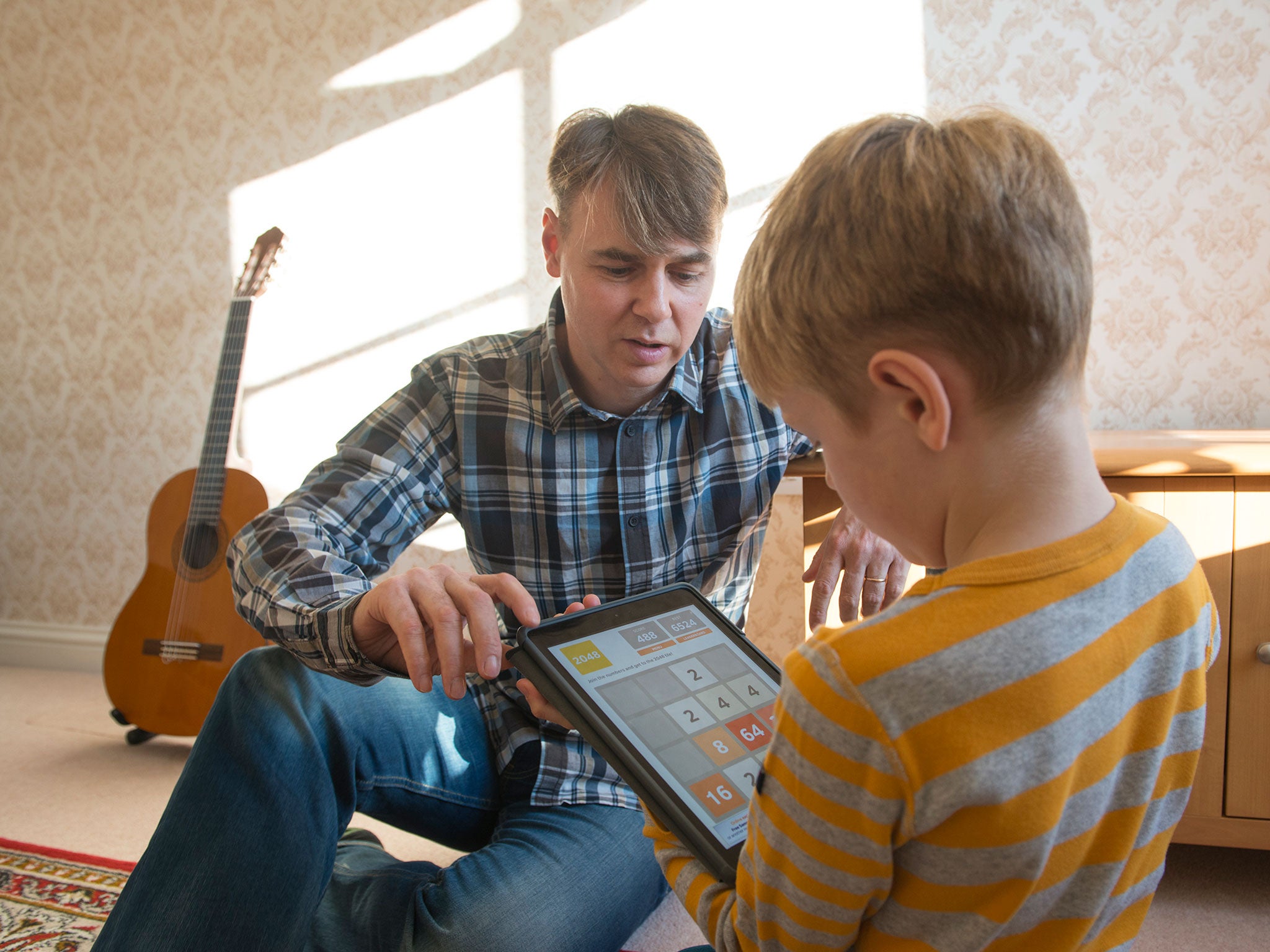 Tom Lewis teaches his son Alexander to use a tablet computer