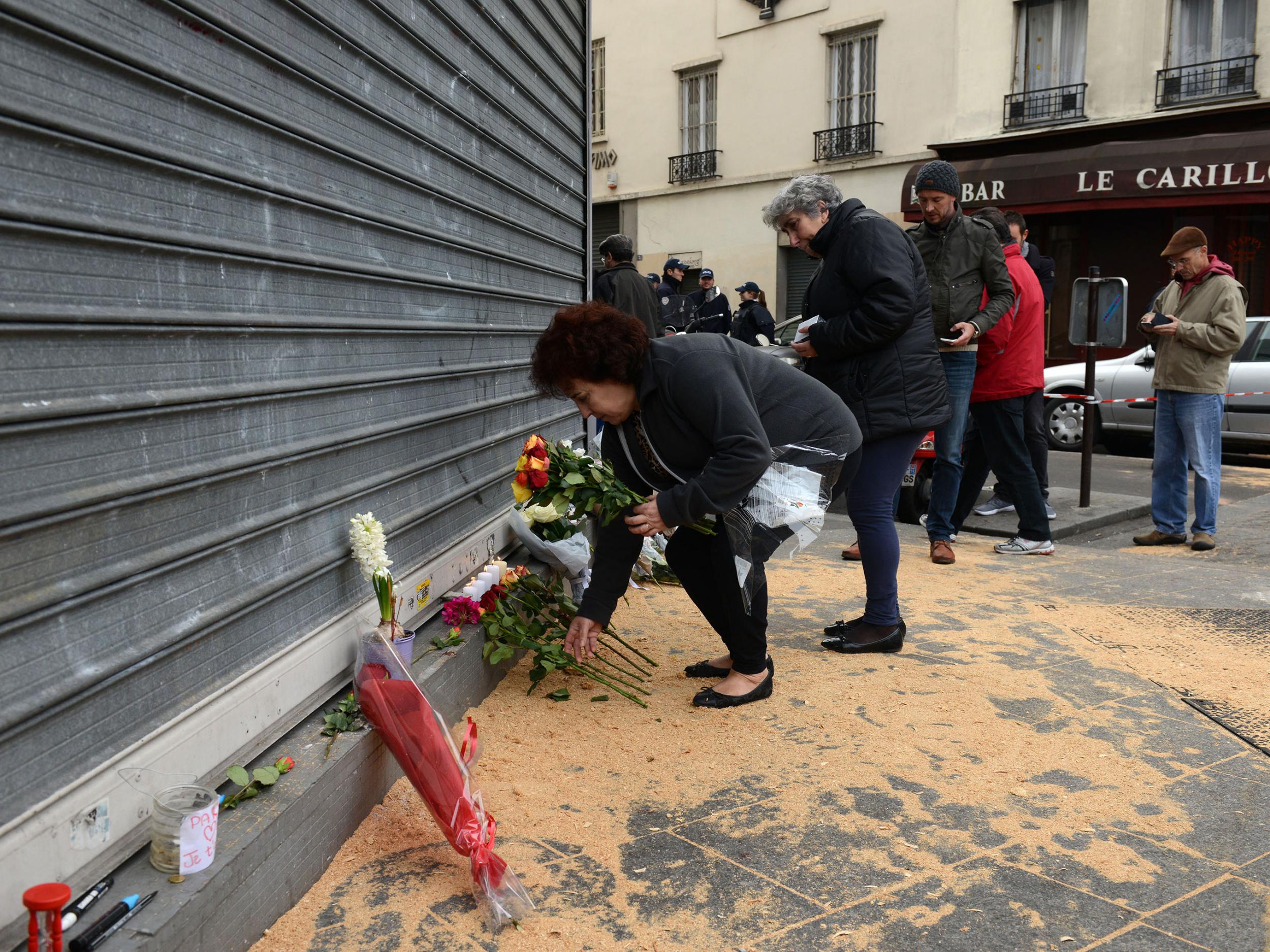 A woman places Flowers outside Le Petit Cambodge restaurant the day after the deadly attacks