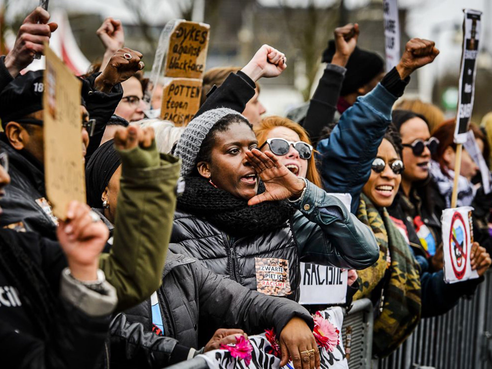 People shoot slogans and hold placards during a demonstration to protest against the racist nature of traditional figure Zwarte Piet in Meppelber