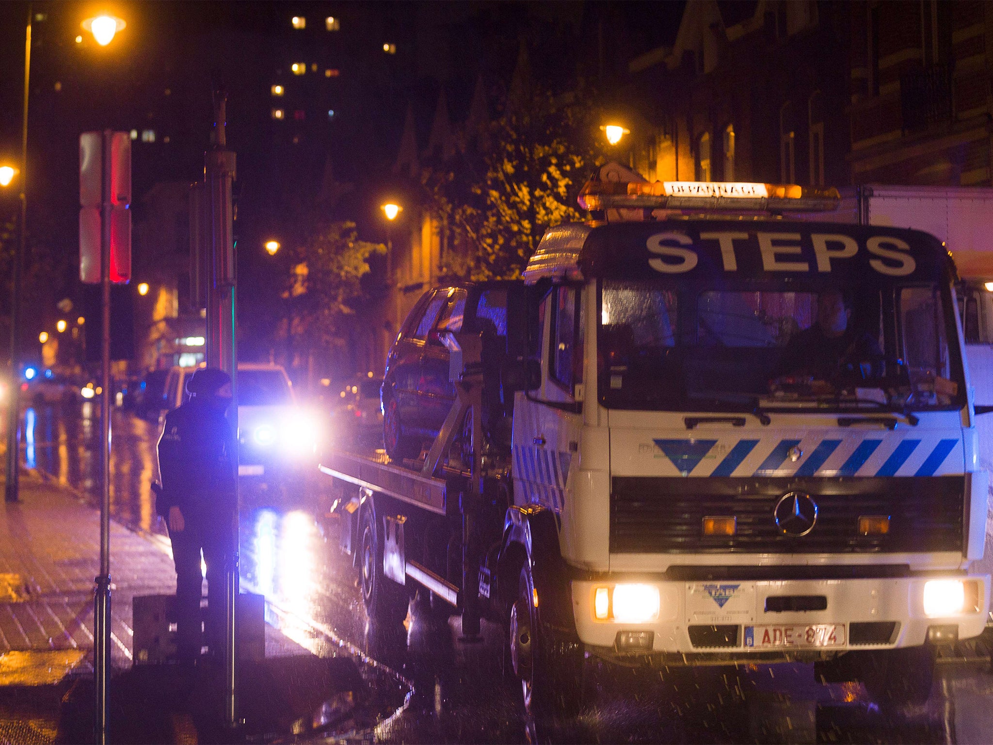 A car is towed during a police raid in Brussels' Molenbeek district in connection with deadly attacks in Paris.