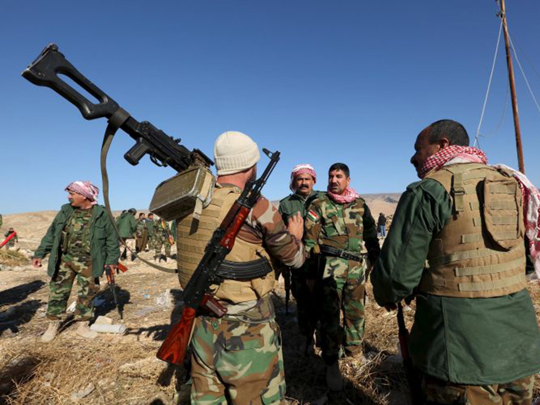 Members of the Kurdish peshmerga forces gather in Sinjar after the town had been taken