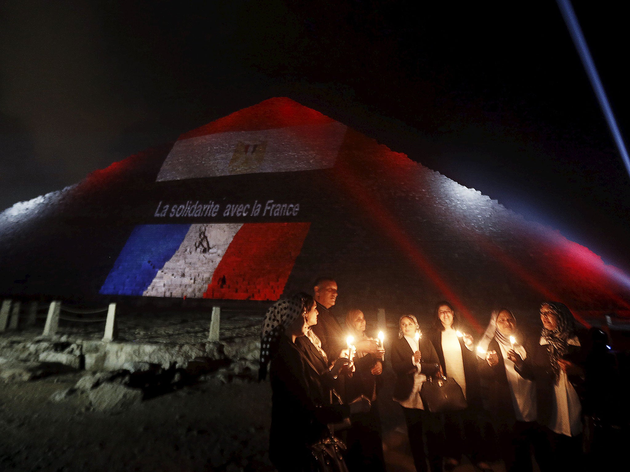 Mourners gather at a makeshift memorial at Le Carillon restaurant, which was targeted in Friday’s attacks