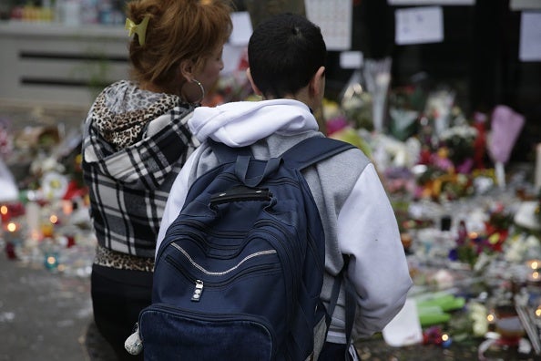 A woman and a her son spend a moment mourning the dead at the site of the attack at the Cafe Belle Equipe on rue de Charonne this morning, prior to going to work and school