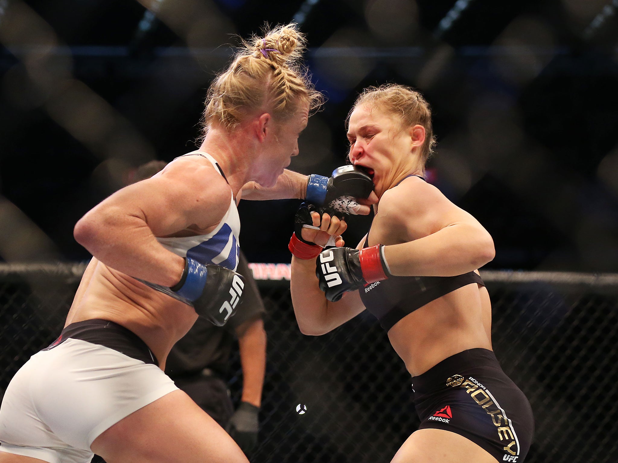 Holly Holm (left) lands a blow on Ronda Rousey