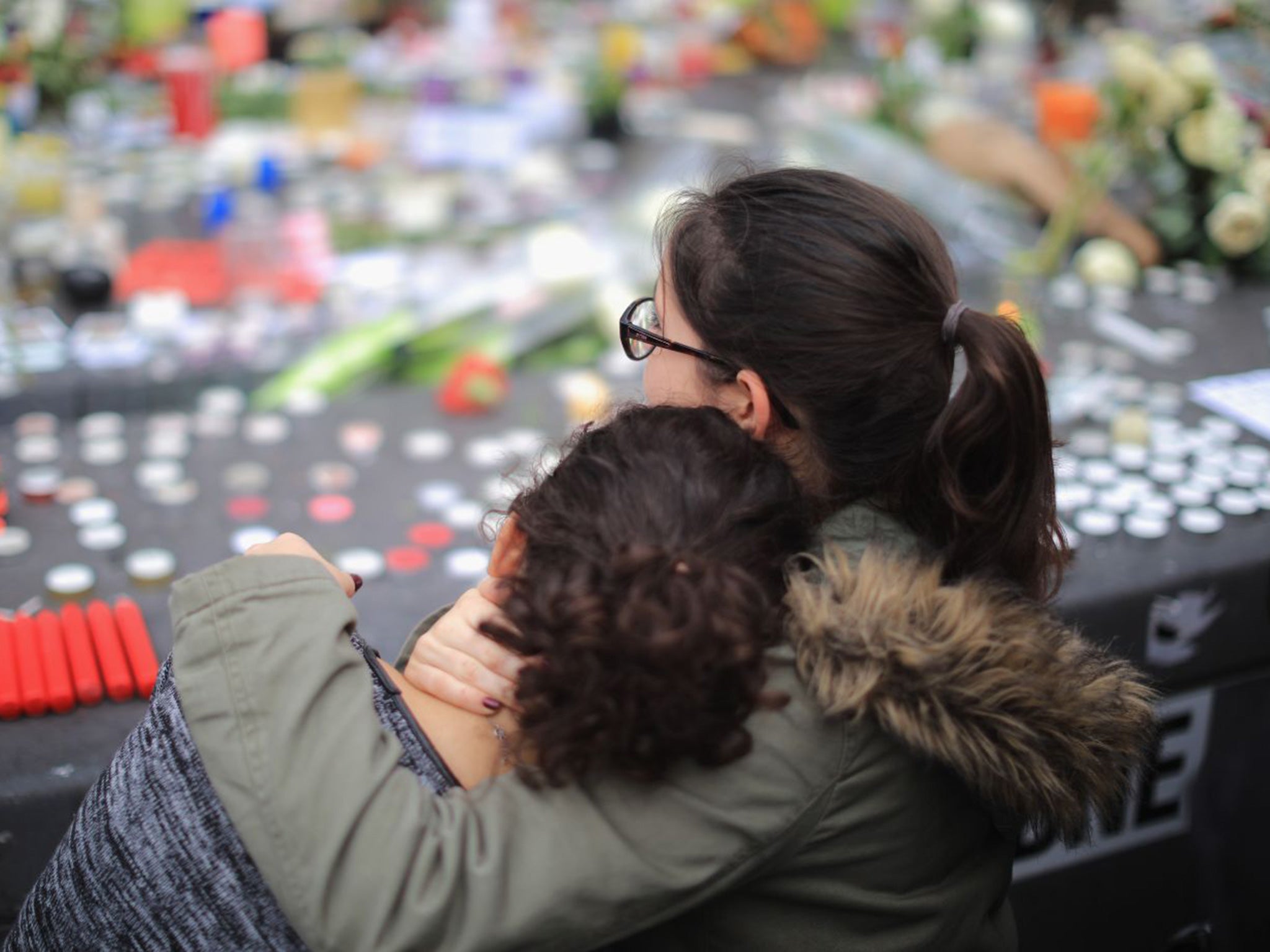 People weep as they gather to observe a minute-silence at the Place de la Republique in memory of the victims of the Paris terror attacks