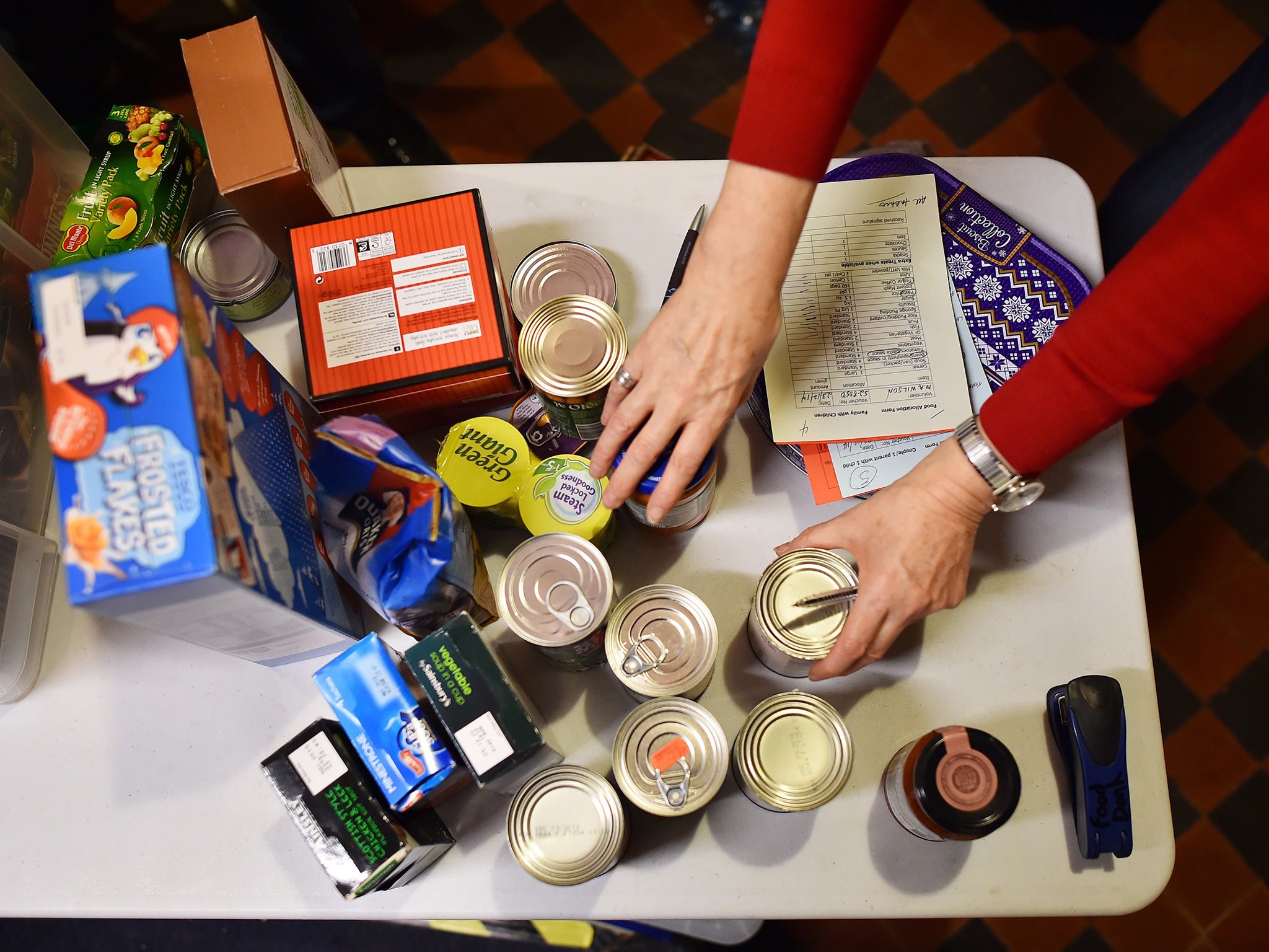 A volunteer selects food for a visitor’s order at a food bank charity in west London