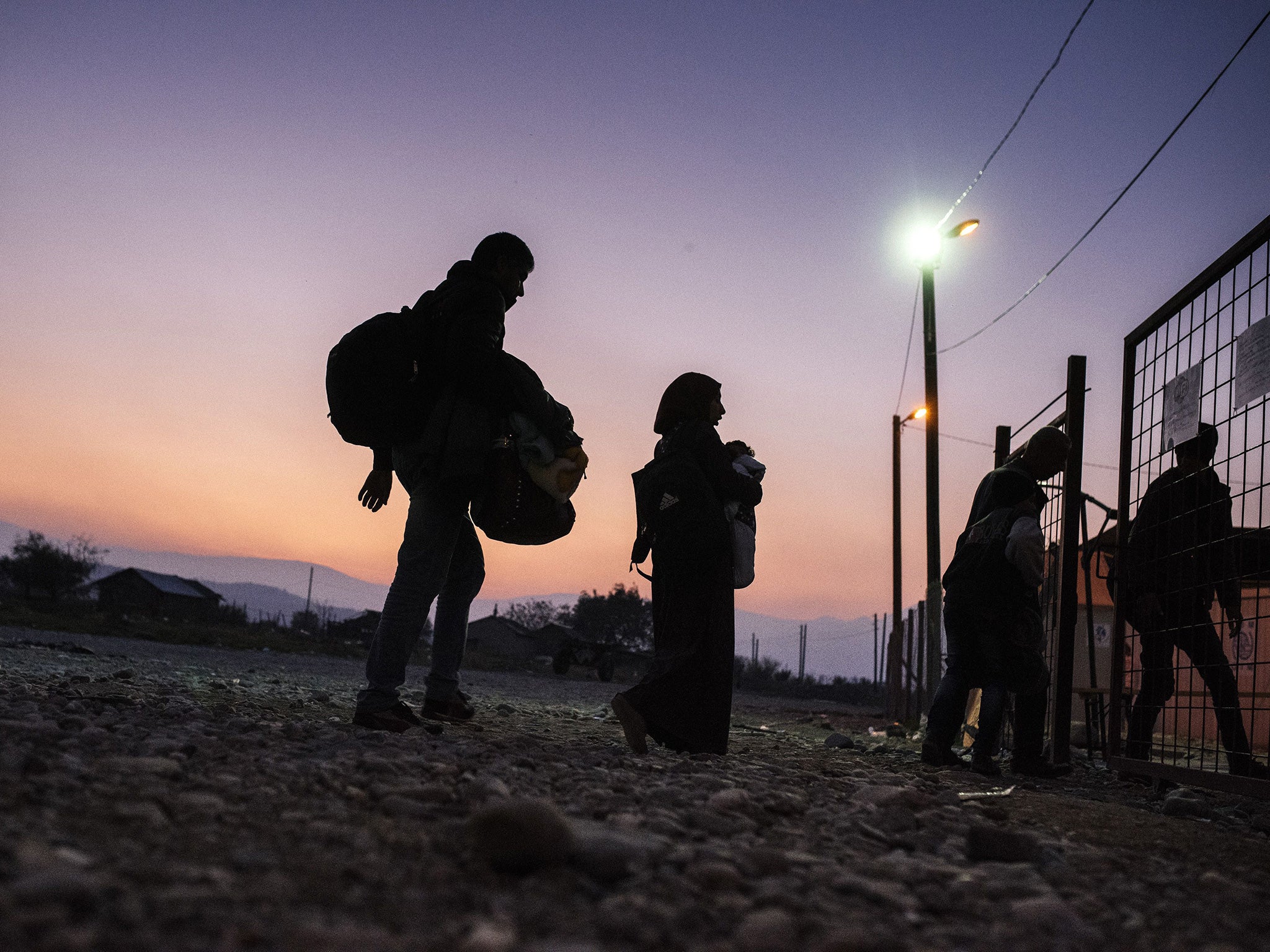 Migrants and refugees enter a registration camp