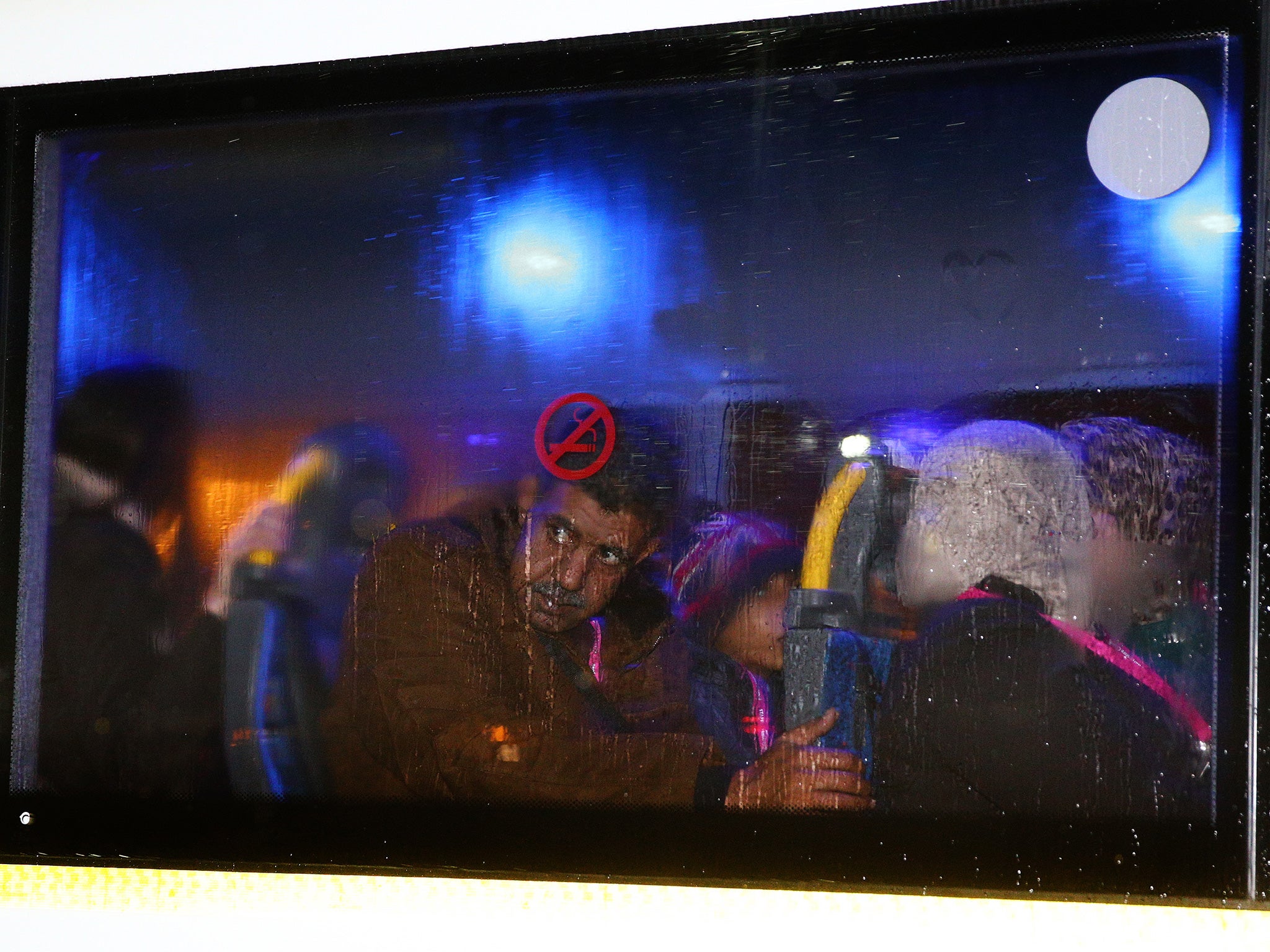 Refugees look out the window as they leave Glasgow Airport on buses after the first of a series of charter flights carrying refugees arrives