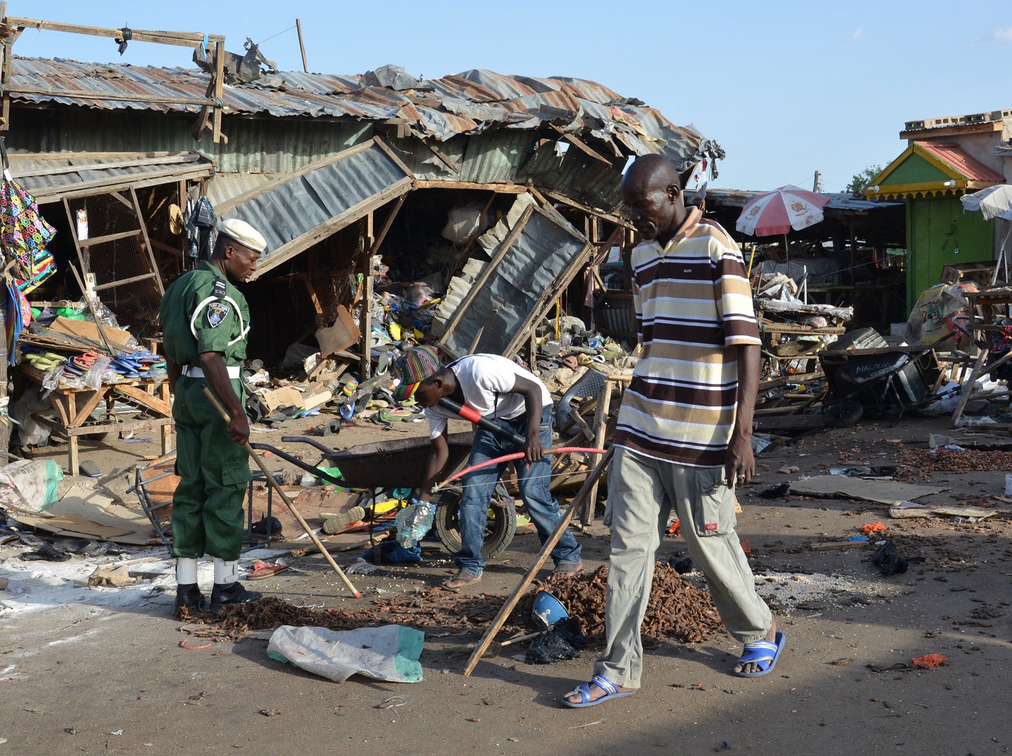 A man walks past a the scene of a bombing after at least 20 people were killed when a young female suicide bomber detonated her explosives at a bus station in Maiduguri, northeast Nigeria in a Boko Haram attack in 2015