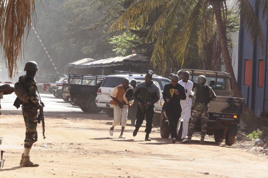 People flee the Radisson Blu hotel after it was stormed by gunmen