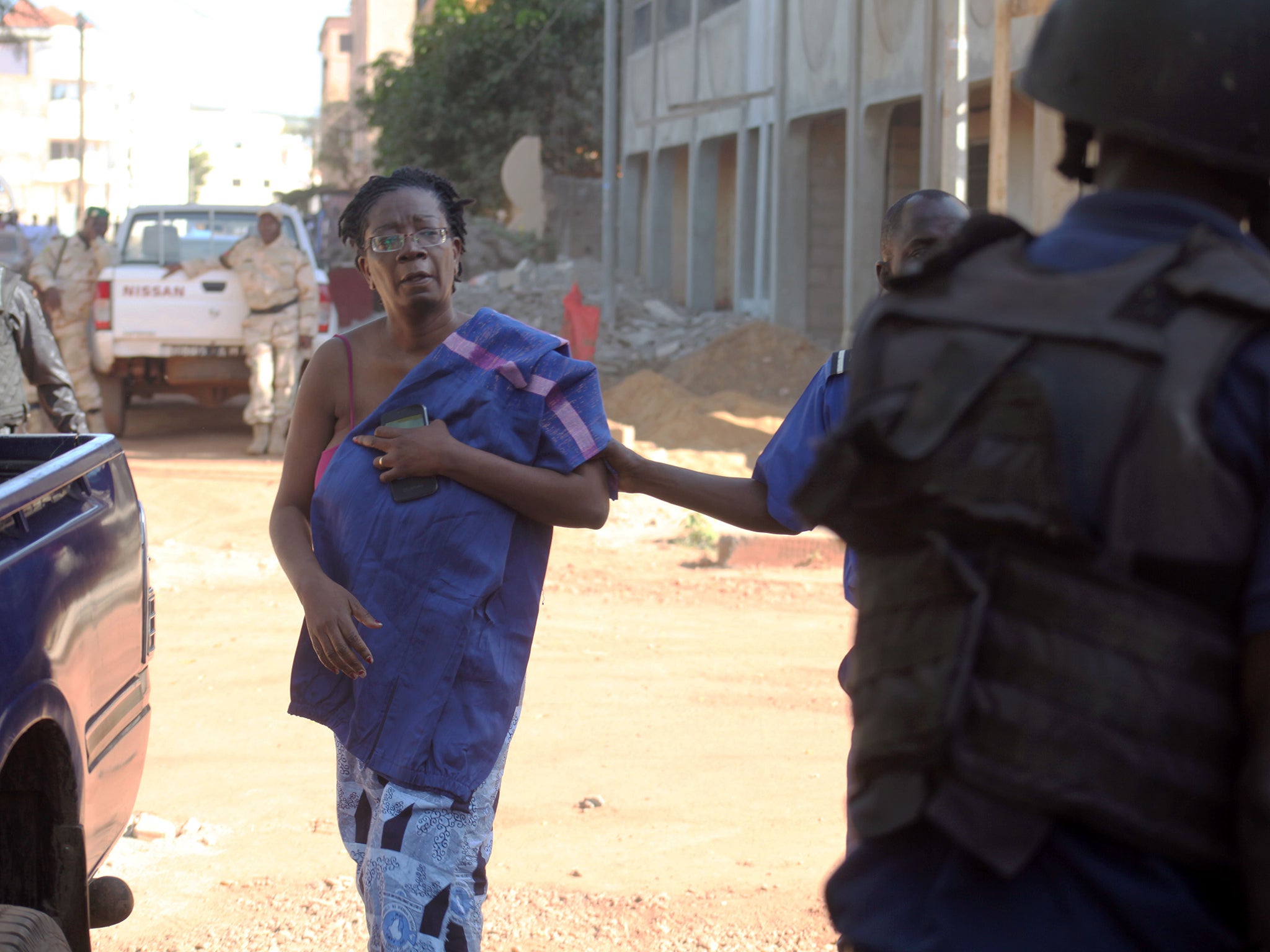 A woman is led away from the Radisson Blu hotel