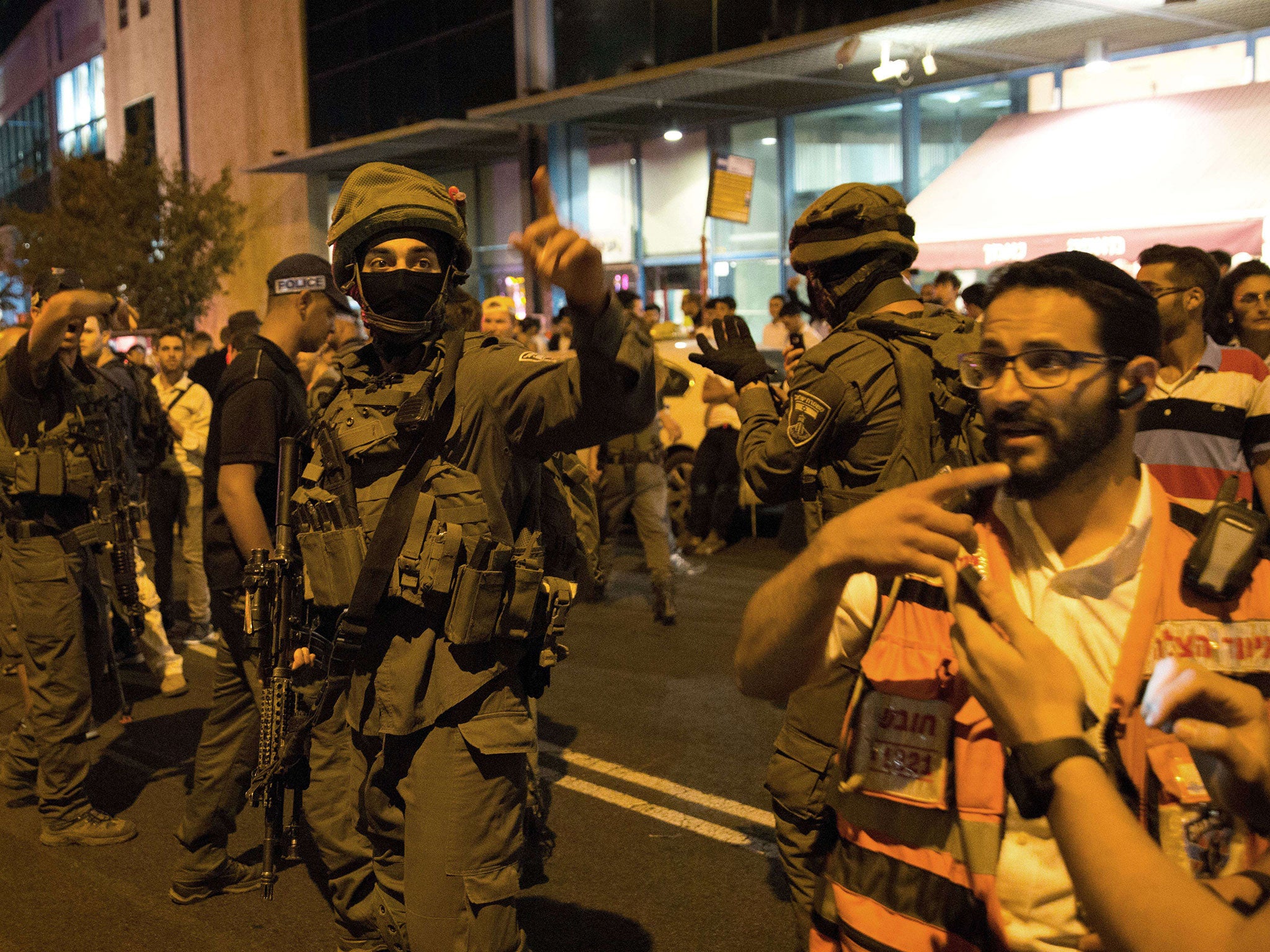 Israeli security forces, police and a medical team arrive at the site where a knife-wielding man stabbed and moderately wounded a woman near Jerusalem's central bus station on October 14, 2015