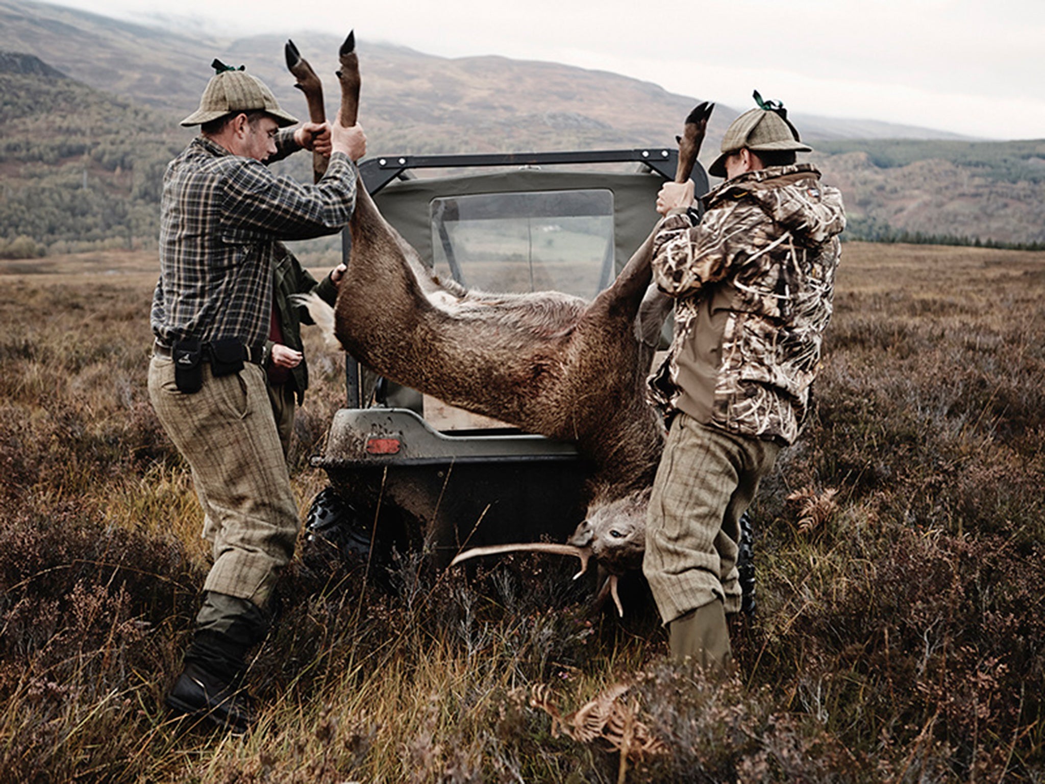 Two hunters load a stag onto their jeep (Photo: Dave Imms)