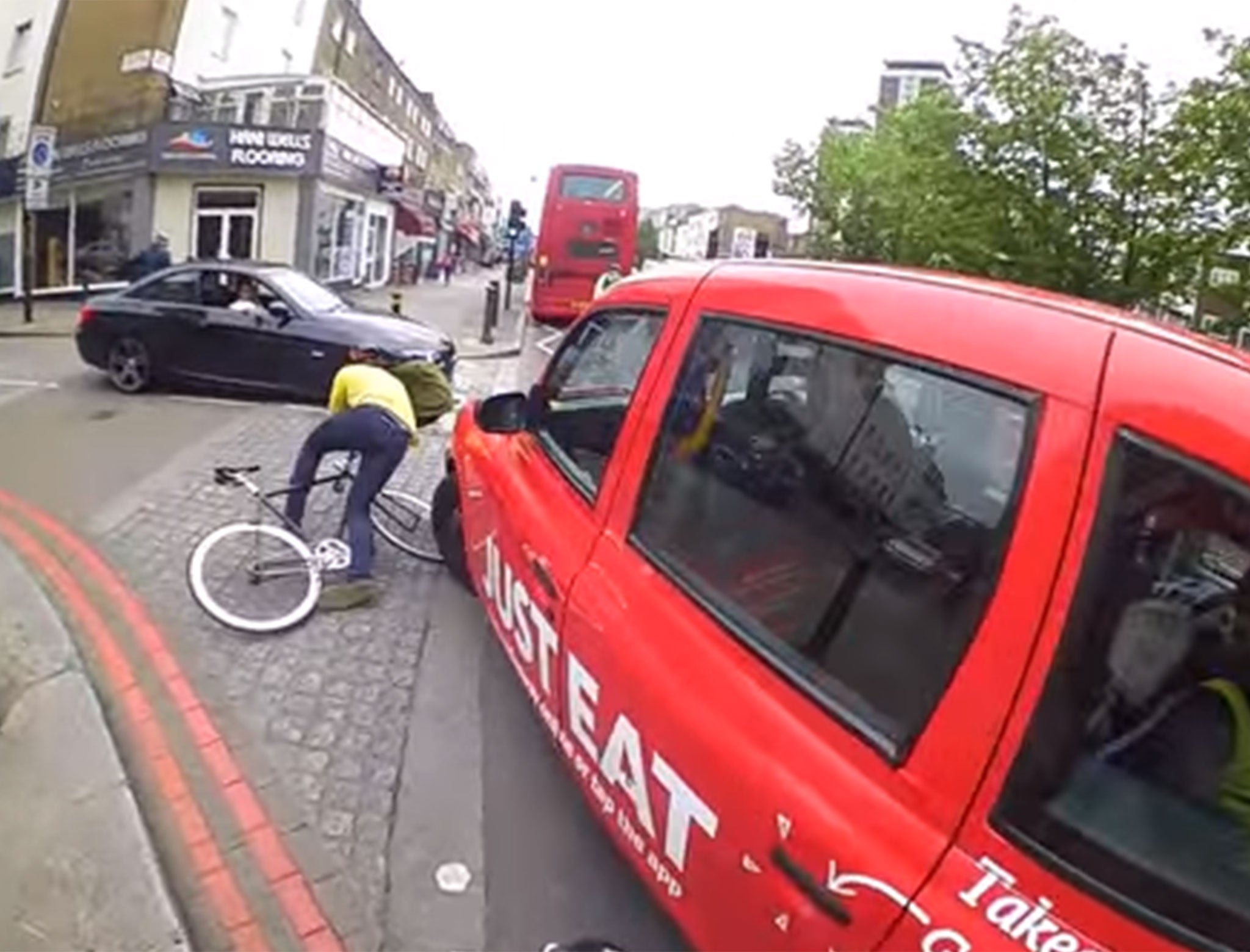 A cyclist is knocked off his bike after attempting to undertake a black cab in London