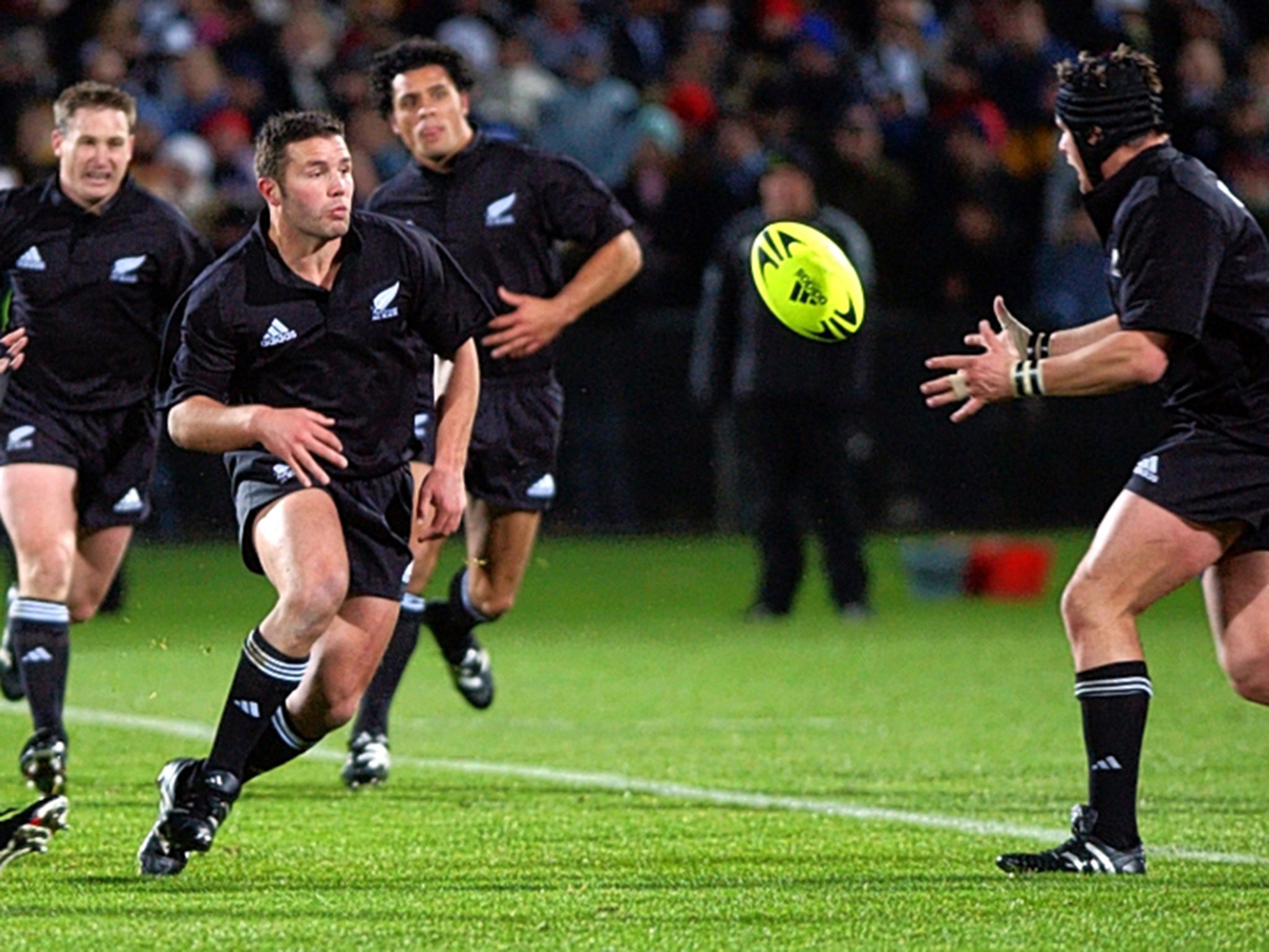 &#13;
Aaron Mauger passes to Richie McCaw for New Zealand in 2002 &#13;