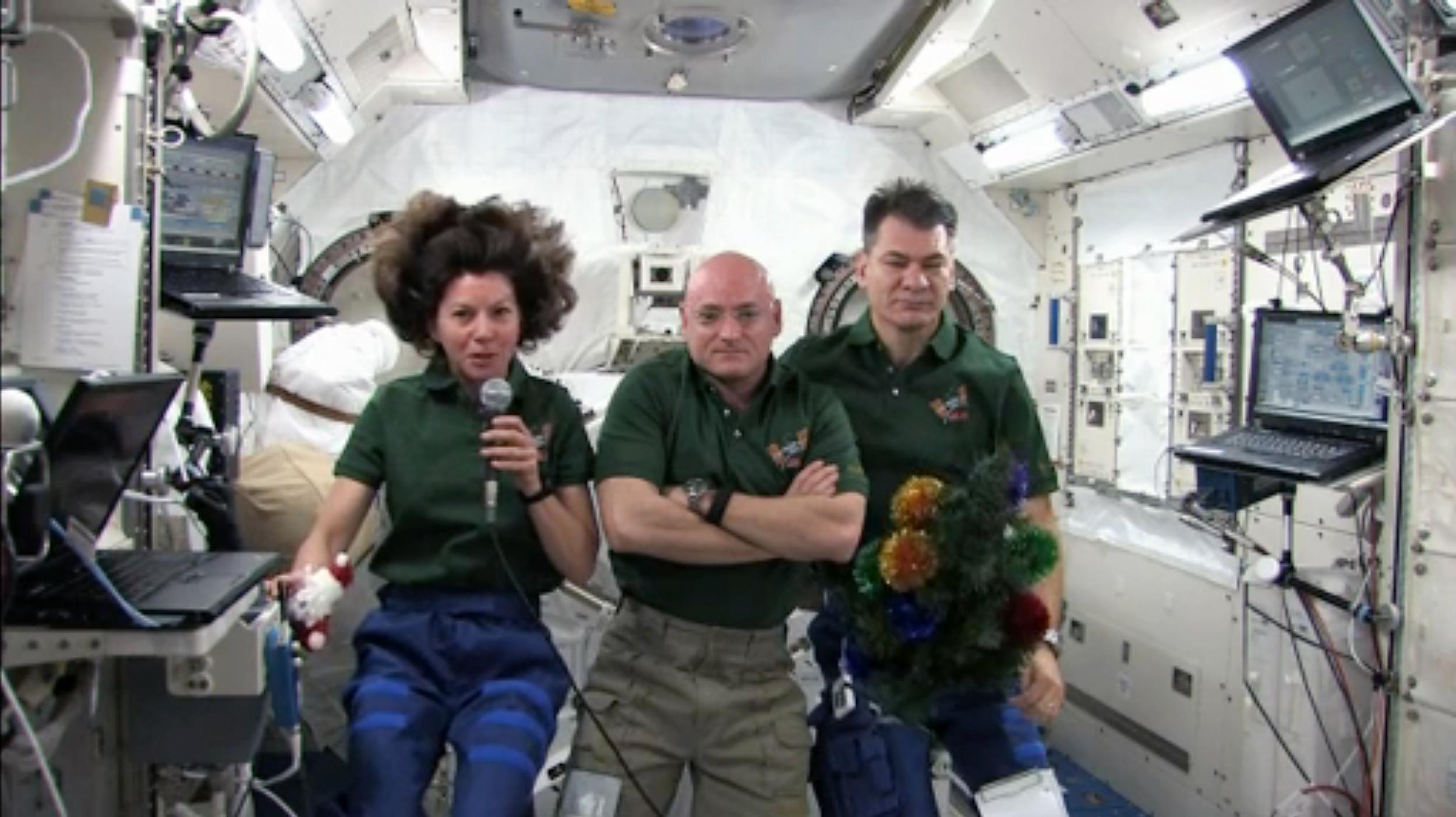 Astronauts Catherine Coleman, Scott Kelly and Paolo Nespoli (L-R) and their mini Christmas tree appear in a Christmas broadcast from the ISS in 2010