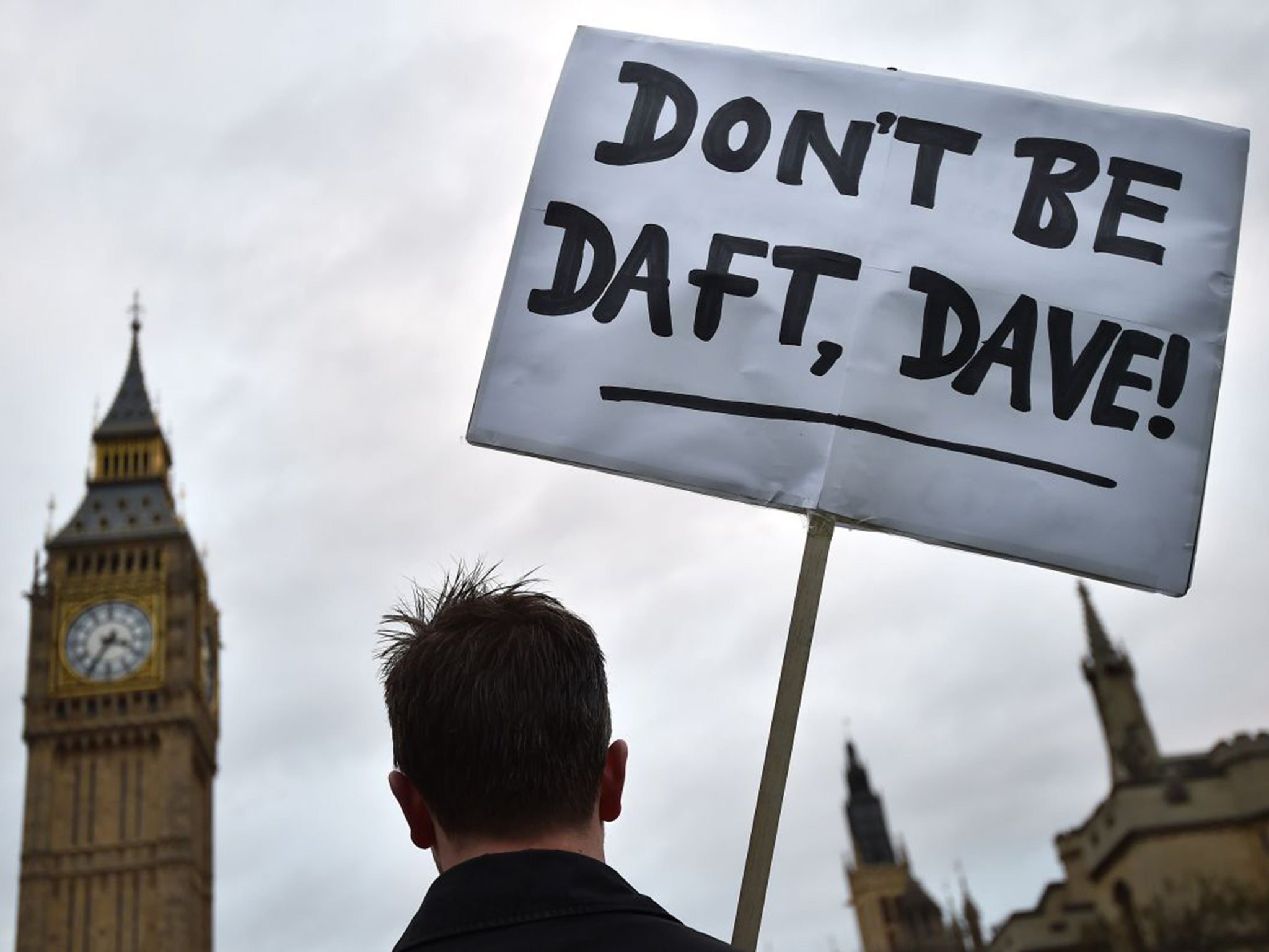 A lone protester opposed to British military action in Syria holds a placard outside the Houses of Parliament