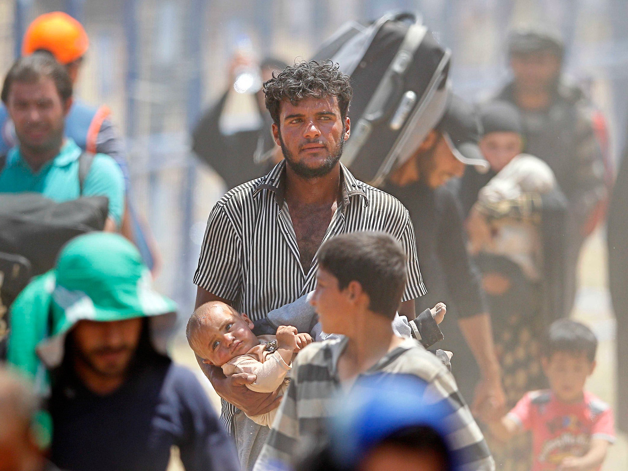 Syrian refugees, crossing the border into Turkey