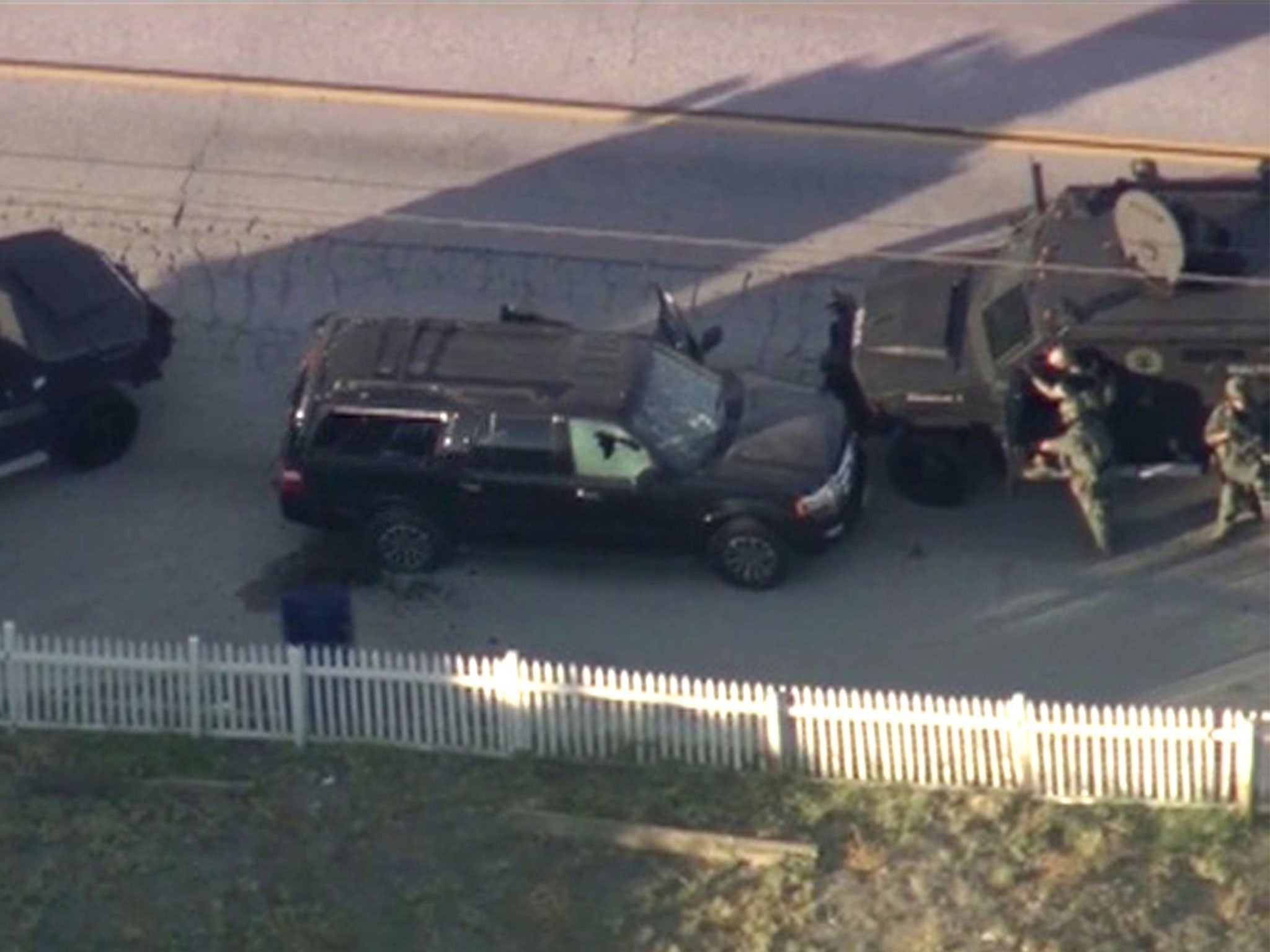 Armoured vehicles surround the SUV driven by the suspects in San Bernardino