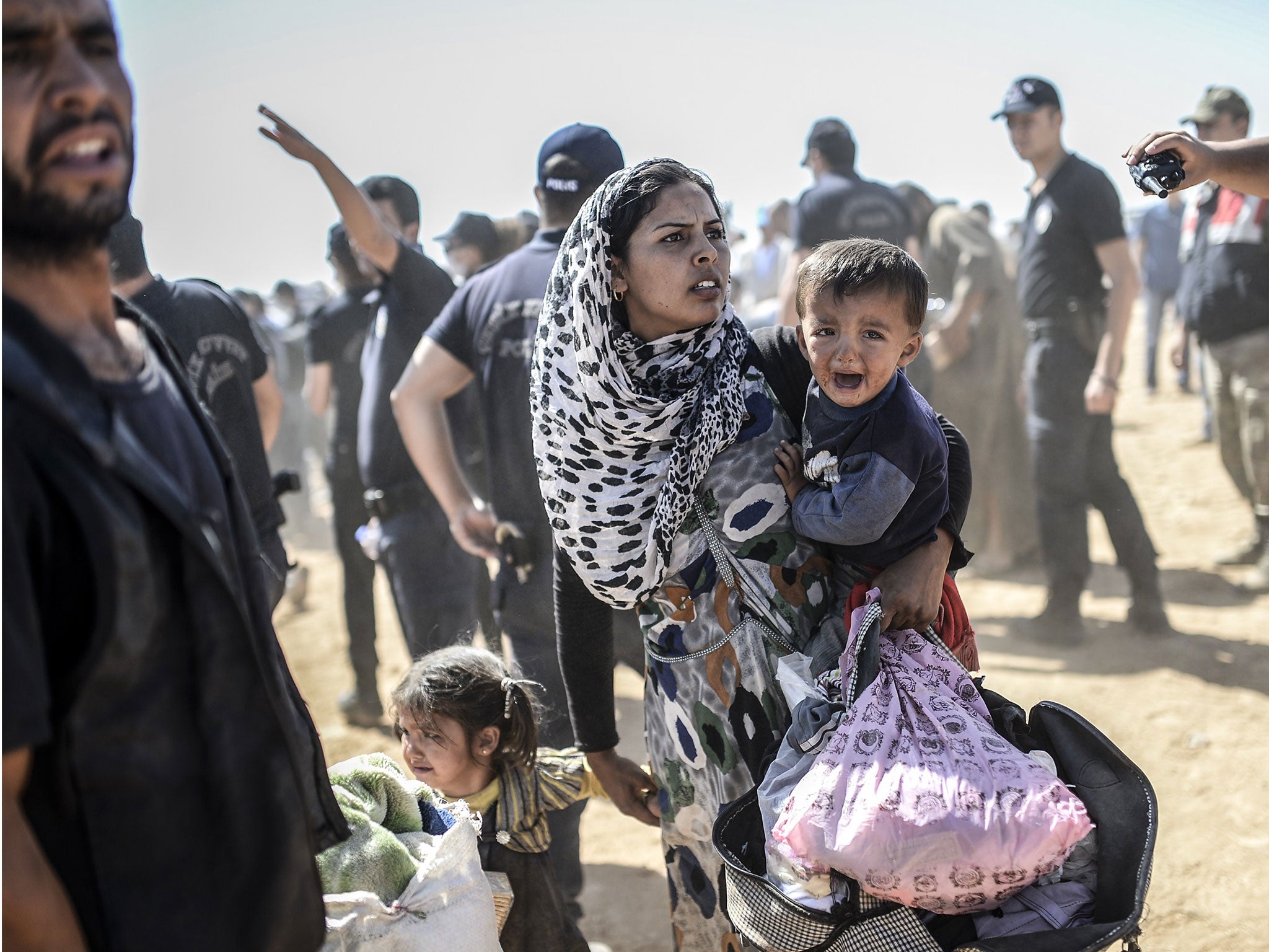 A Syrian Kurdish woman crosses the border between Syria and Turkey at the southeastern town of Suruc in Sanliurfa province on 23 September, 2014