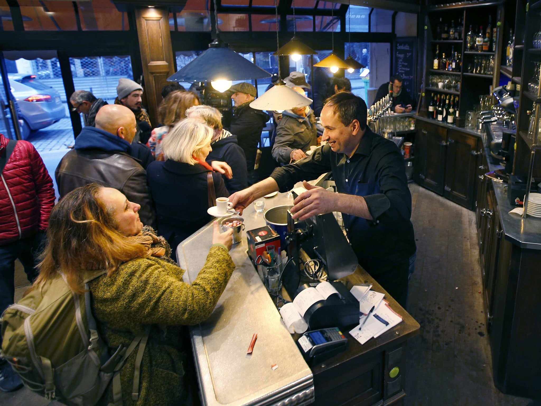 Customers stand at the counter inside "A La Bonne Biere" cafe in Paris, France, December 4, 2015, as it re-opens for business