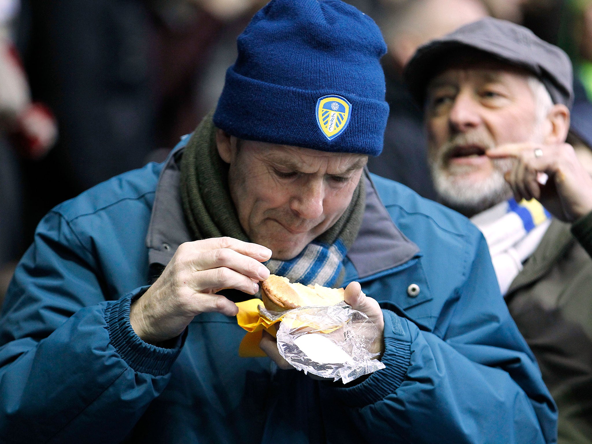 A Leeds fan enjoys a pie during the match against Hull